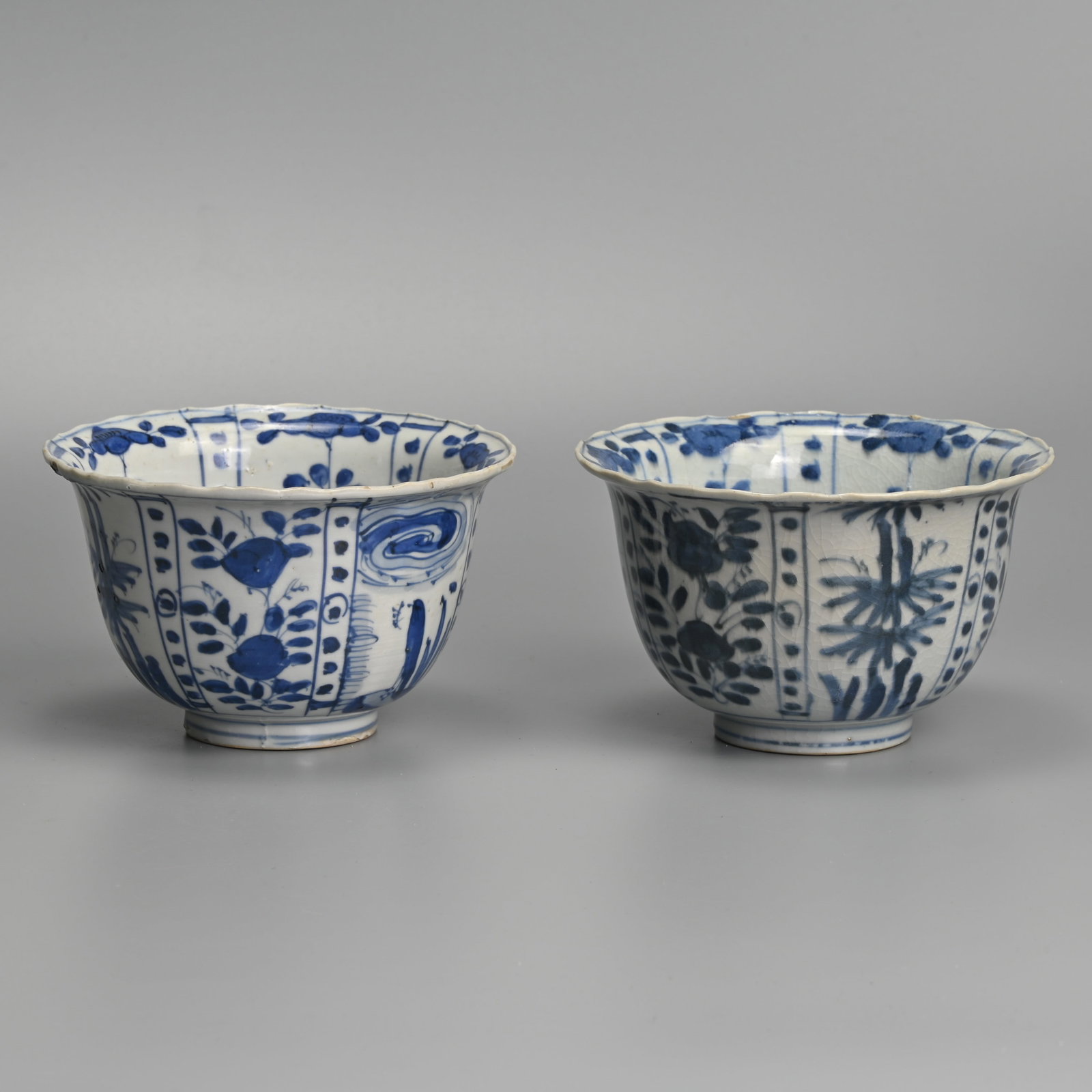 A MATCHED PAIR OF CHINESE KRAAK PORCELAIN BLUE AND WHITE CROW BOWLS, LATE MING DYNASTY, WANLI PERIOD: Each with flared rim, painted with a crow before plants in landscape alternating with panels of flowers and bamboo, approx. 13 cm diam. (2) Provenance: Private collection, Japan.