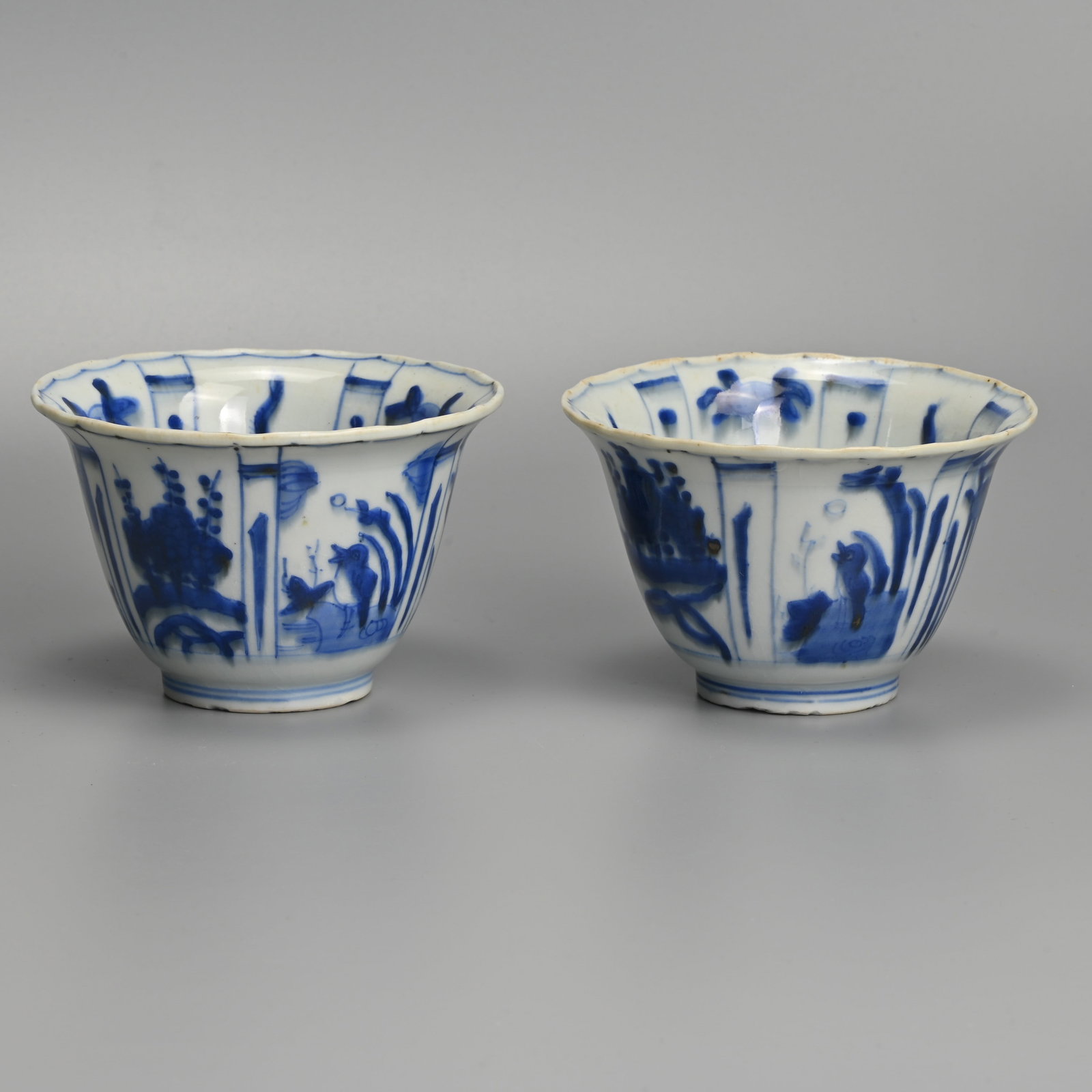 A MATCHED PAIR OF CHINESE KRAAK PORCELAIN BLUE AND WHITE CROW BOWLS, LATE MING DYNASTY, WANLI PERIOD: Each with flared rim, the interior painted with a crow before plants in landscape, within panels of tall plants and fruiting plants, the exterior with alternating panels of flowers, figures before pav