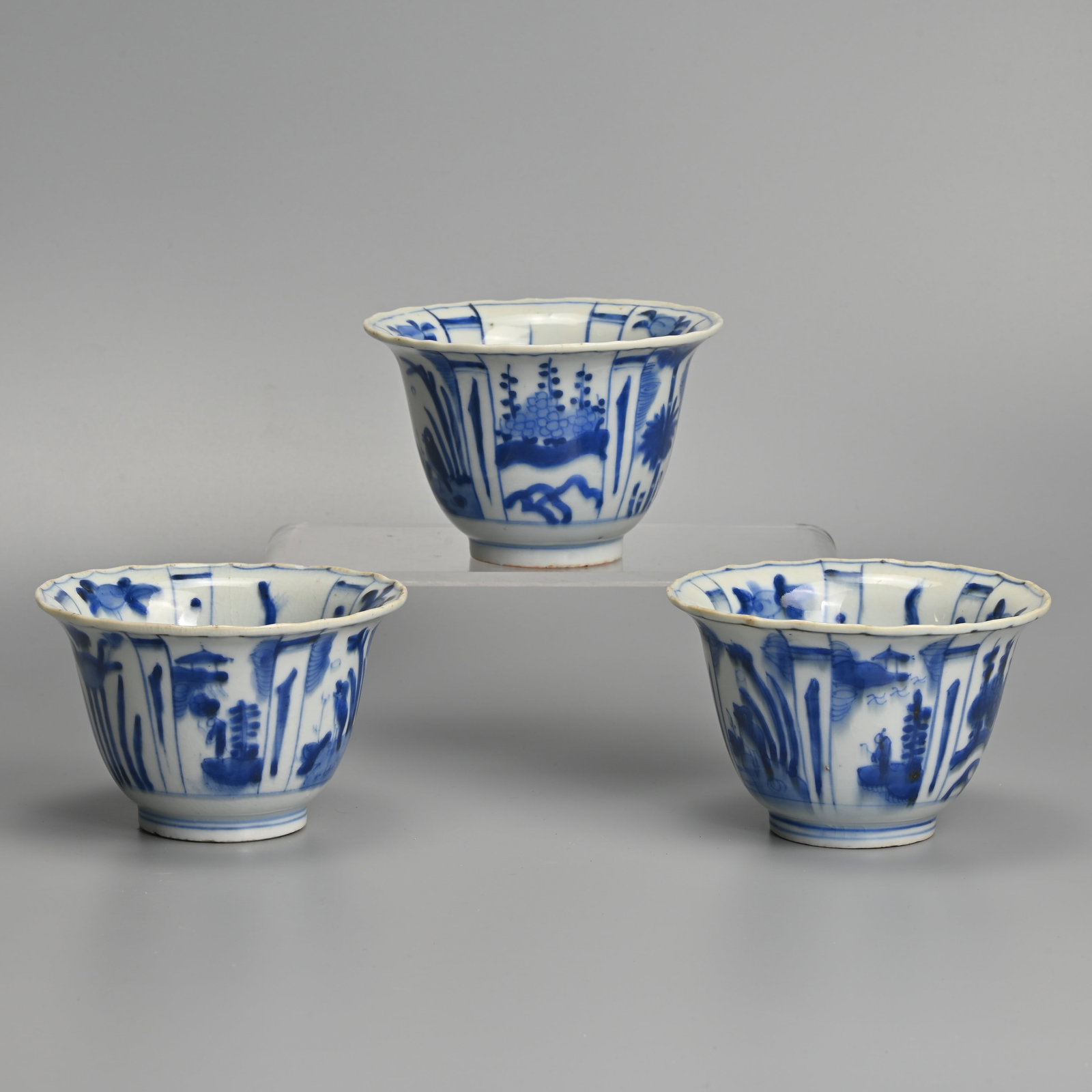 A MATCHED SET OF THREE CHINESE KRAAK PORCELAIN BLUE AND WHITE CROW BOWLS, LATE MING DYNASTY, WANLI: Each with flared rim, the interior painted with a crow before plants in landscape, within panels of tall plants and fruiting plants, the exterior with alternating panels of flowers, figures before pav