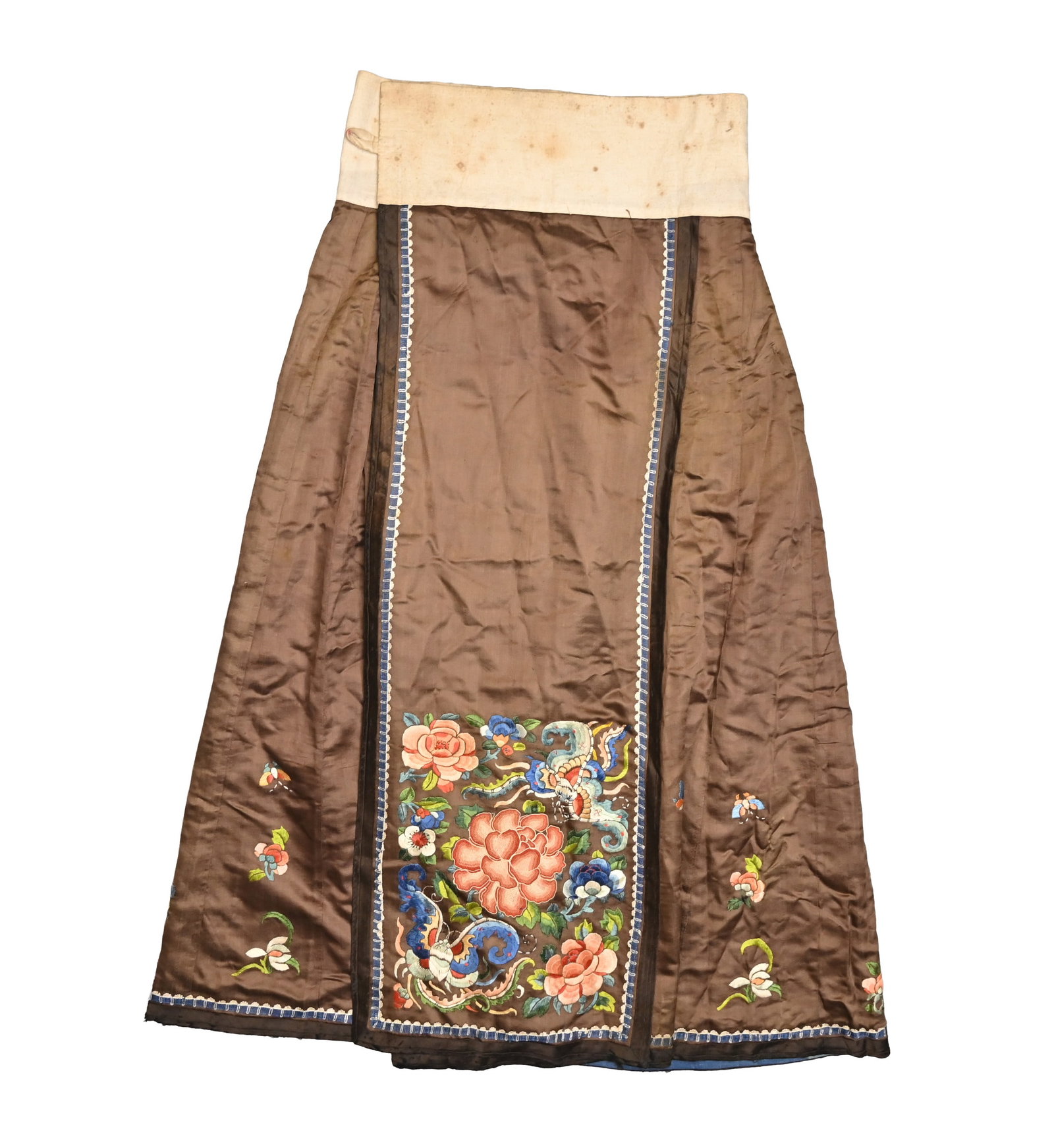 A CHINESE EMBROIDERED BROWN GROUND SILK SKIRT, LATE QING DYNASTY, CIRCA 1900.: Embroidered in coloured silk threads with bats before peony, flowers and leaves and further scattered flowers and butterflies, within a blue and white border and dark brown trim, with cream cotton wai