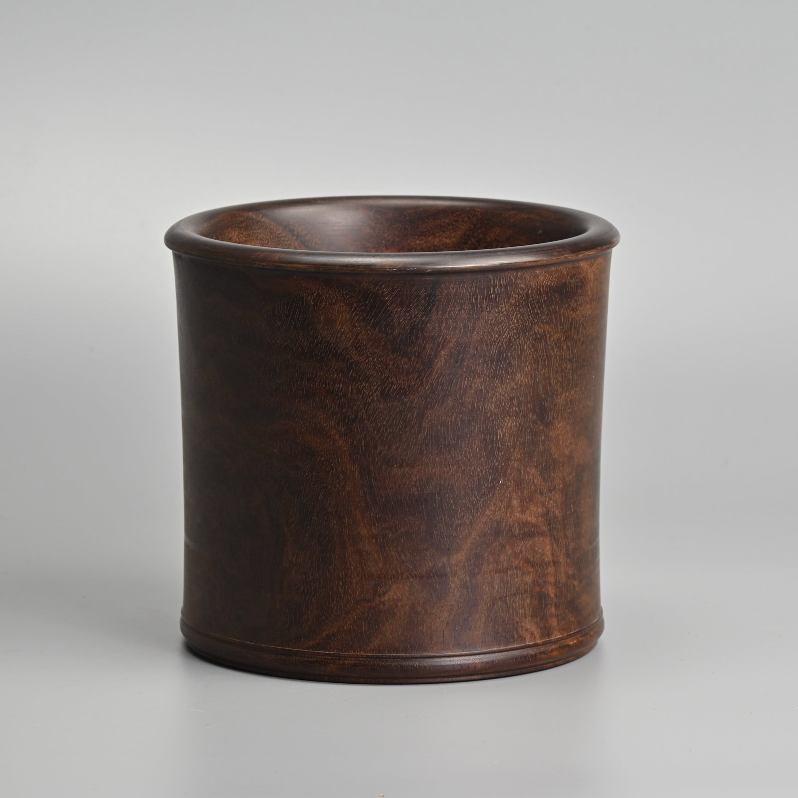 A CHINESE ZITAN HARDWOOD BRUSH POT, 20TH CENTURY.: Of slightly waisted cylindrical form with beaded edge at the mouth and turned band around the foot. 16cm tall x 17cm diam.