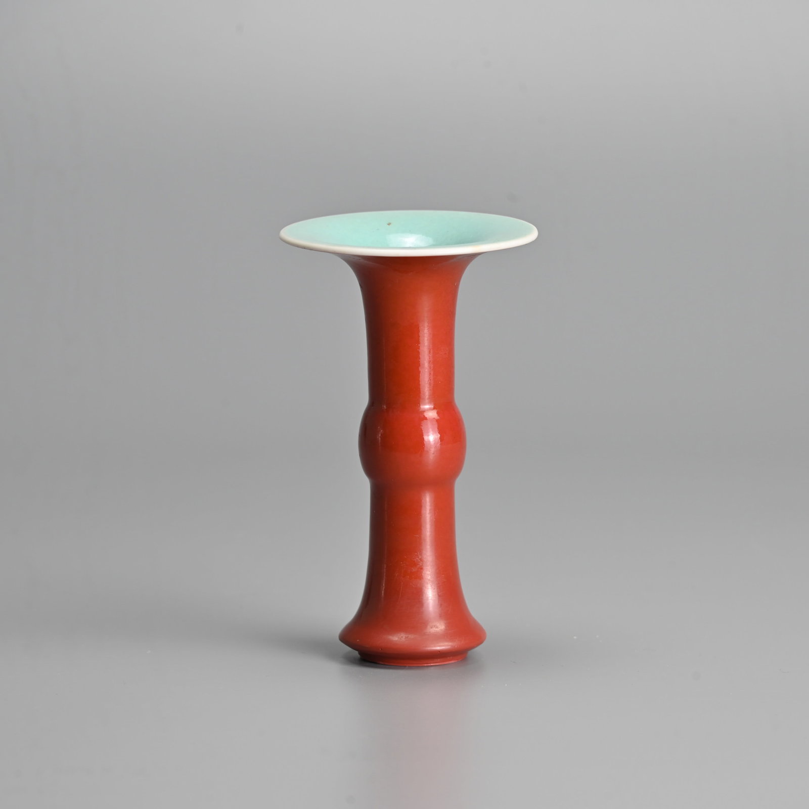 A CHINESE CORAL GROUND MINIATURE GU SHAPED PORCELAIN VASE, 19/20TH CENTURY.: The exterior covered in a deep coral ground with a turquoise glazed interior and base. 11cm tall.