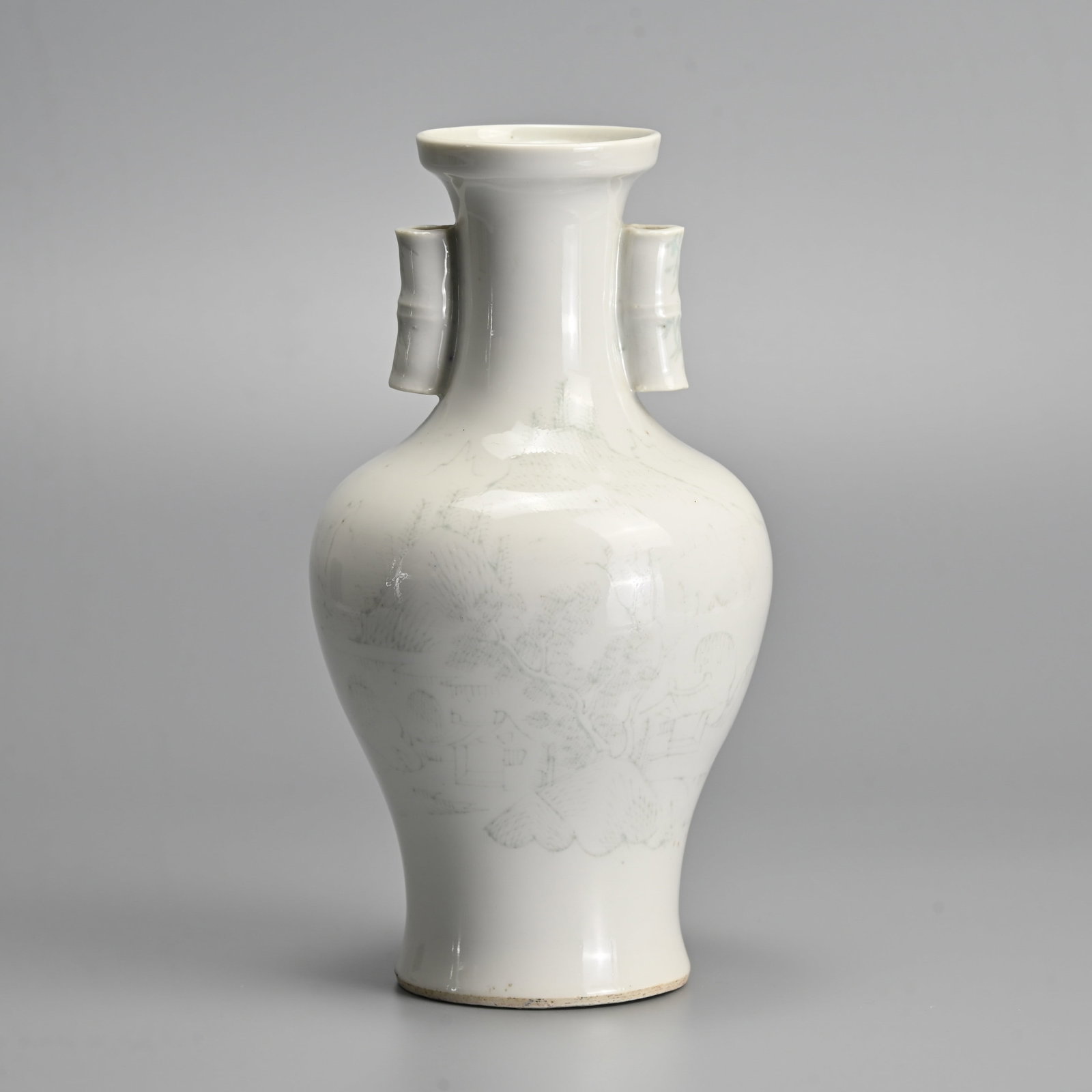 A CHINESE WHITE GLAZED PORCELAIN 'ARROW' VASE, EARLY 20TH CENTURY.: Of baluster form with two hollowed bamboo-form tubular handles. Decorated with landscape scene and buildings before hills and trees. 22.5cm tall.