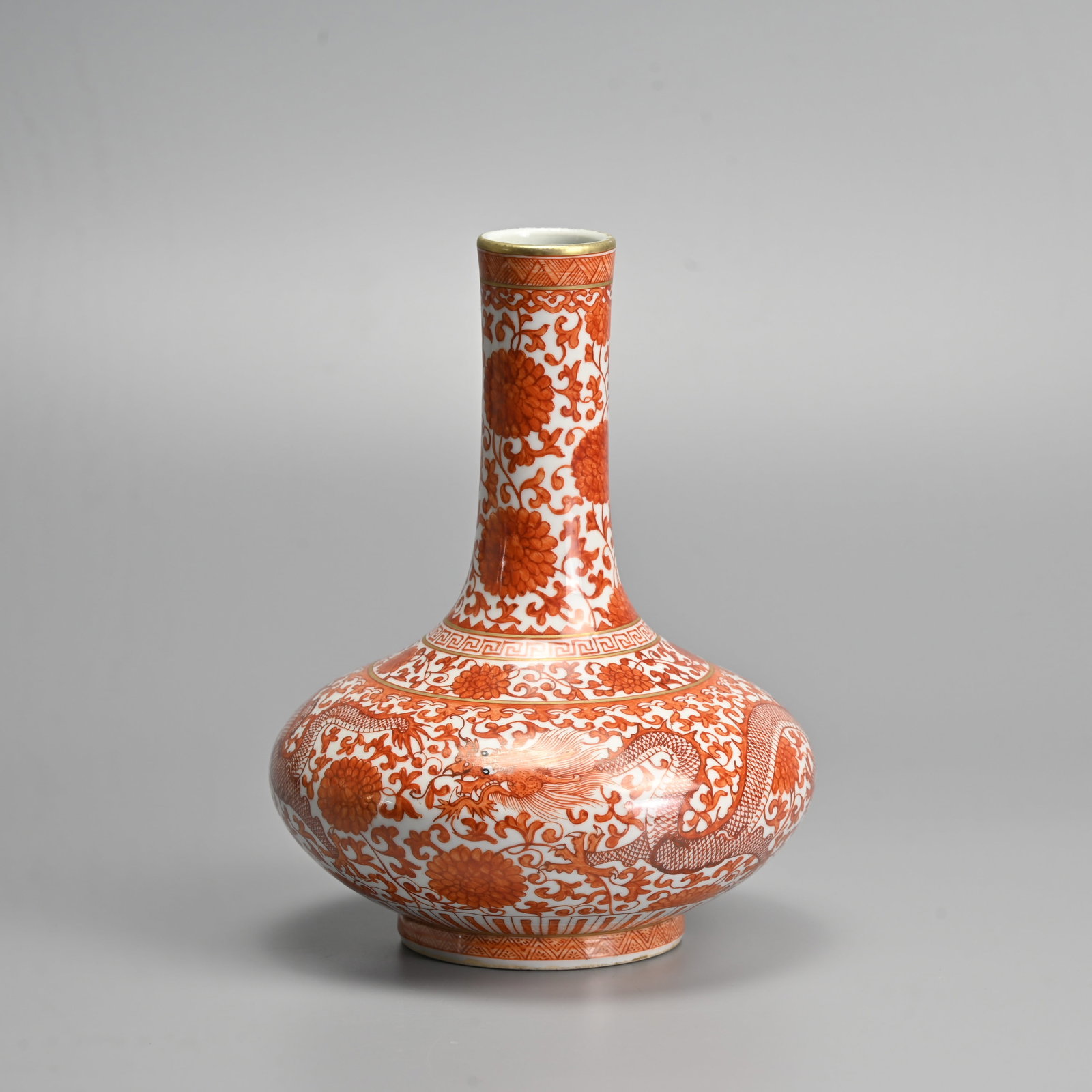 A CHINESE IRON RED AND GILT DECORATED PORCELAIN VASE, QIANLONG MARK.: Decorated with dragons amidst lotus scrolls. Six character seal mark of Qianlong to base in underglaze blue. 21cm tall.