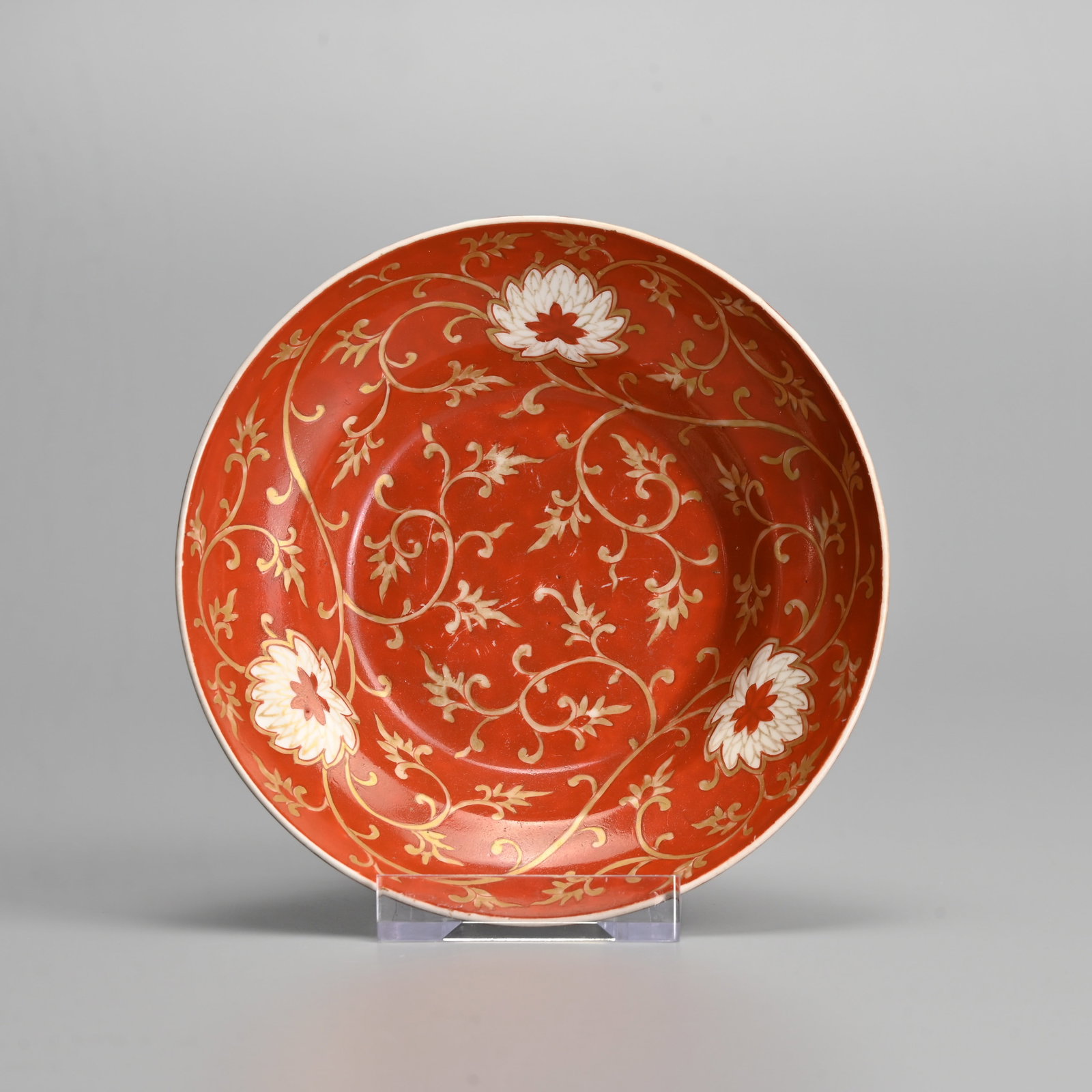 A CHINESE CORAL GROUND AND GILT DECORATED PORCELAIN 'LOTUS SCROLL' DISH, 19/20TH CENTURY.: Decorated with lotus heads on leafy tendrils, the base with 'Shou' longevity roundel. 13cm diam.