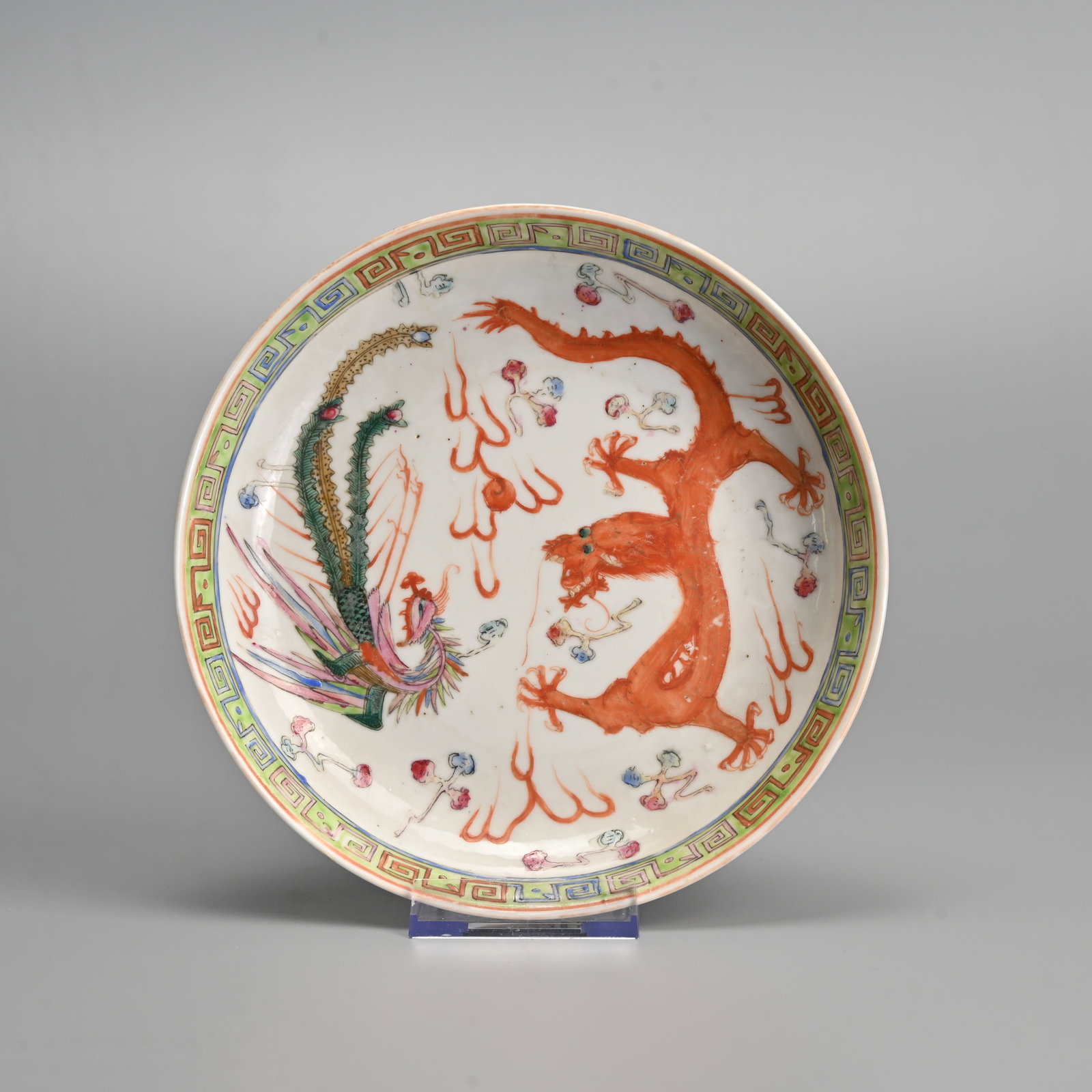 A CHINESE FAMILLE ROSE PORCELAIN 'DRAGON AND PHOENIX' DISH, GUANGXU MARK, REPUBLIC PERIOD.: Decorated with dragon and phoenix in flight amidst flames and ruyi clouds within a band of key fret at the rim. Six character mark of Guangxu to base. 18.5cm.