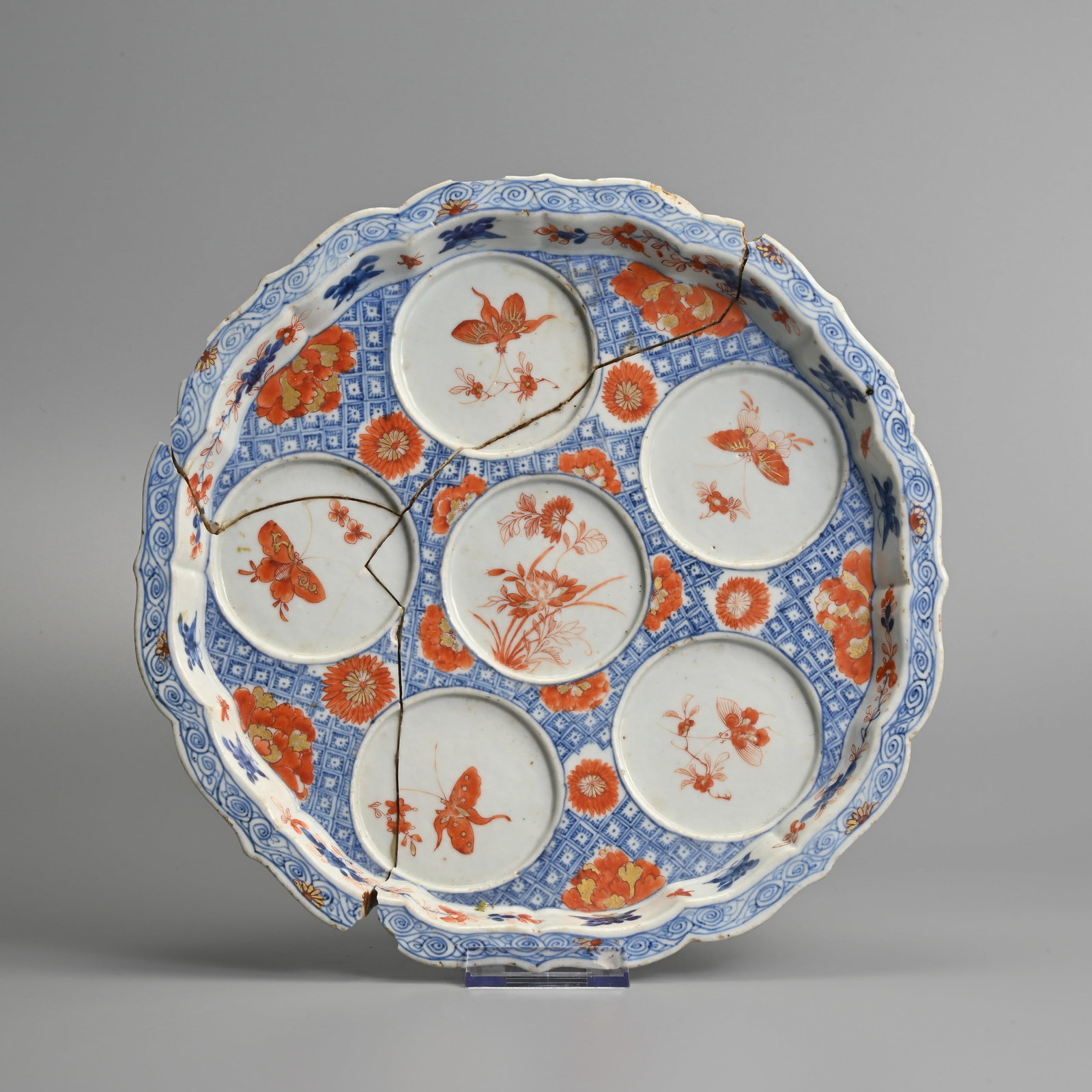 A RARE CHINESE IMARI STYLE BRACKET LOBED PORCELAIN SWEETMEAT DISH, 18TH CENTURY.: With five internal circular dish sections decorated with various, flower heads, butterflies and floral sprays in iron red and gilt reserved on an underglaze blue diaper pattern ground. 30cm diam.