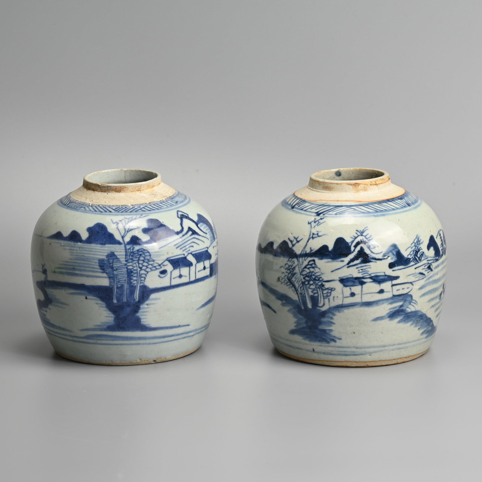 A PAIR OF CHINESE BLUE AND WHITE PORCELAIN GINGER JARS, 19TH CENTURY.: Decorated with landscape scene with buildings and fisherman. 16cm tall x 17cm wide. (2).