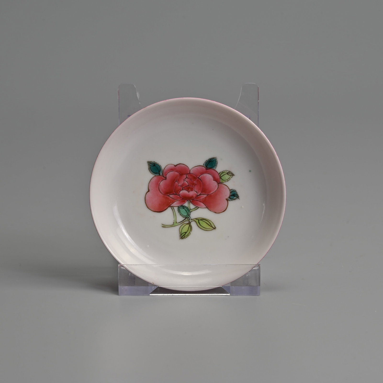 A SMALL CHINESE FAMILLE ROSE RUBY BACKED PORCELAIN 'PEONY' DISH.: With a singe peony spray to the interior, the exterior covered in a bright ruby coloured ground. 7.6cm diam.