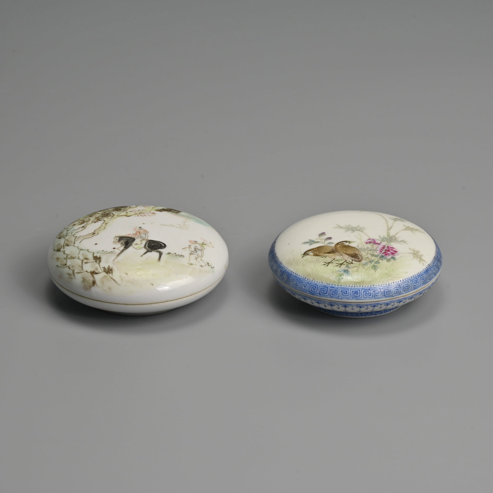TWO CHINESE PORCELAIN PASTE BOXES AND COVERS, REPUBLIC PERIOD, TONGZHI AND SHI LU MARKS.: Of circular form. The first qianjiang cai decorated with a figure on horseback followed by attendant, he base with four character mark of Tongzhi; Together with a famille rose enamelled box featuring 