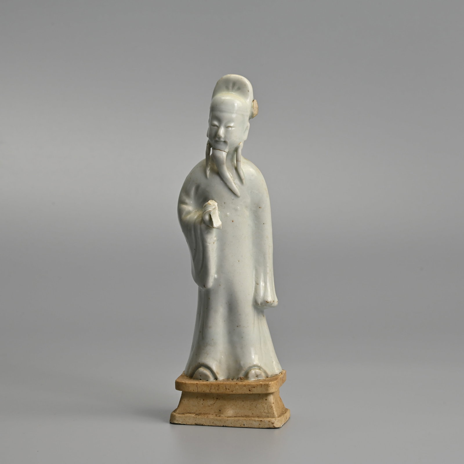 A CHINESE GLAZED BISCUIT PORCELAIN FIGURE OF A SCHOLAR, 18TH CENTURY.: The figure covered in a white glaze leaving the base unglazed. 19cm tall.