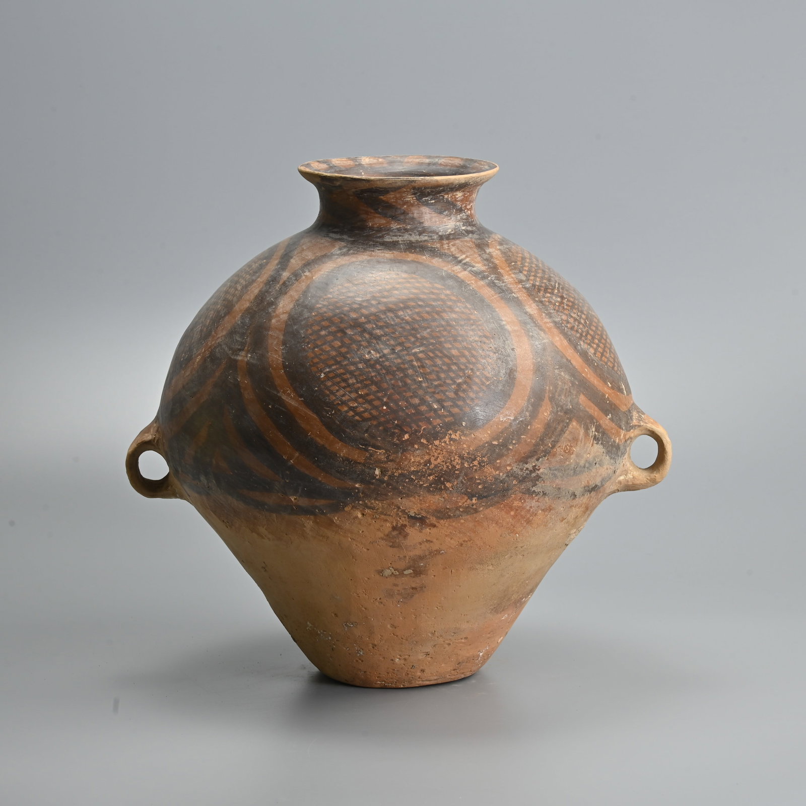 A FINE AND LARGE CHINESE NEOLITHIC POTTERY JAR, LIUWAN TYPE, MACHANG PHASE (C.2300 - 2000 BC).: Made from a fairly high-fired buff-coloured pottery, the surface colour varying in places due to uneven firing conditions. It is well-proportioned with its smooth round body, small circular base, wide
