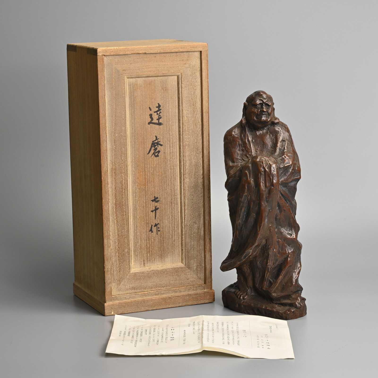 A JAPANESE VINTAGE BRONZE MODEL OF DARUMA, SHINYA NAKAMURA (B.1926), LATE 20TH CENTURY.: Signed lower near base. In singed wooden tomobako box. 34cm tall x 15cm wide x 9cm deep. Weight 5.1kg.