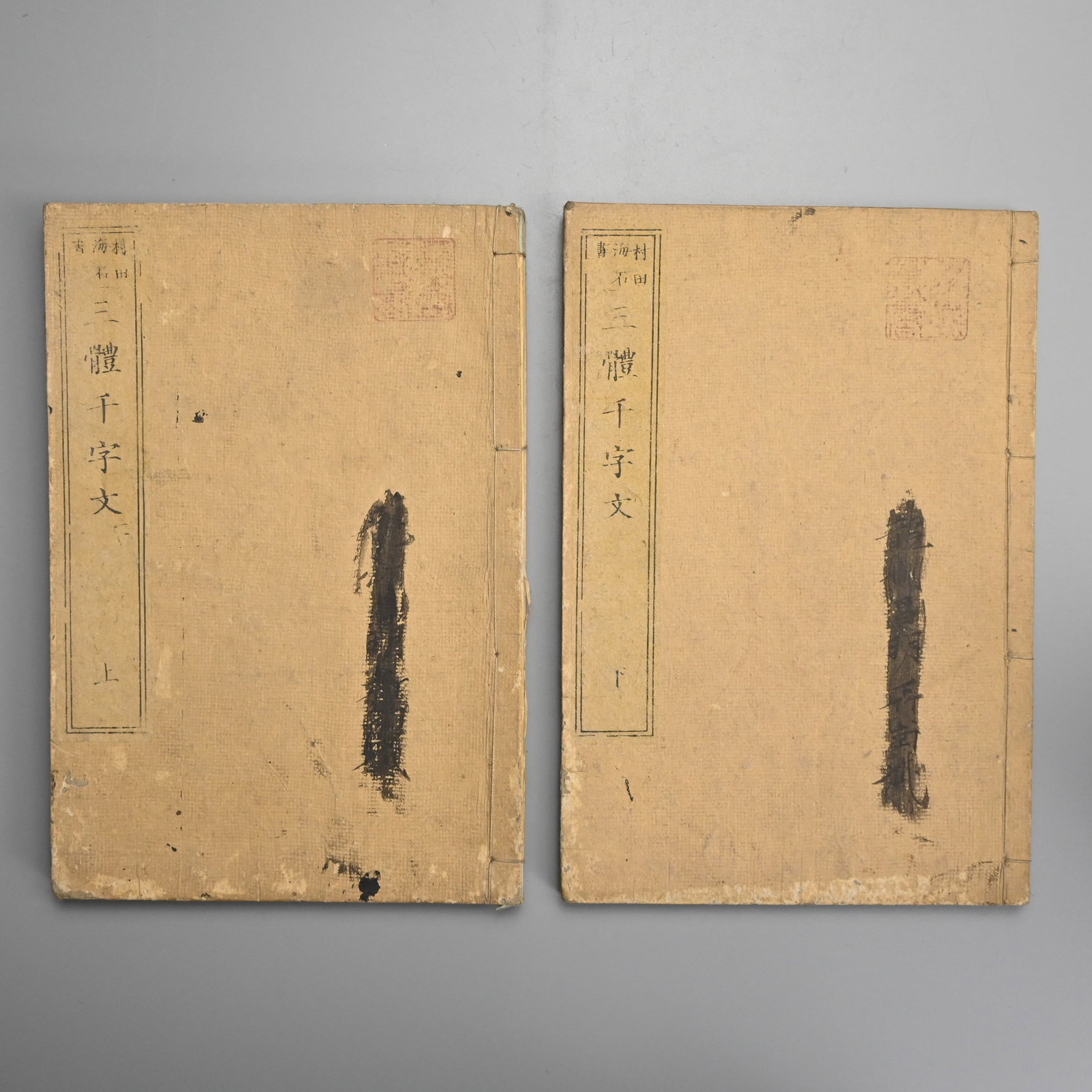 SANTAI SENJIMON (ONE THOUSAND CHINESE CHARACTERS IN THREE STYLES) BY MURATA KAISEKI.: Complete in two volumes. Drab pale brown card covers, side stitched binding. Pasted on title labels. Meiji 14, 1881. The Thousand Character in Three Styles was a Chinese classic dating back to the Son