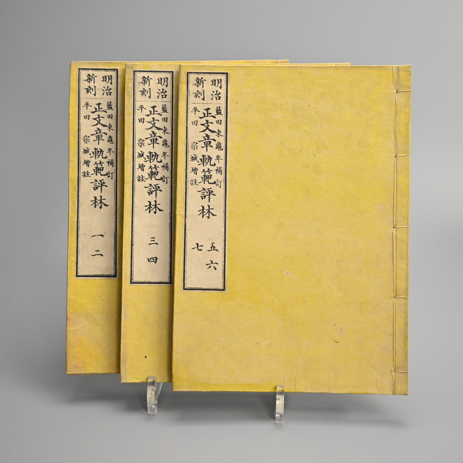 SEI MONSHO KIHAN HYORIN, A THREE VOLUME SET ON JAPANESE HERALDRY AND MONS (FAMILY CRESTS).: Stab stitched and bound in plain yellow card covers with title labels to each. Dated 1876. Edited by Hirata Sojyo. With an ownership stamp or hanko to the front of each volume. 26 x 18.5cm. Provenance