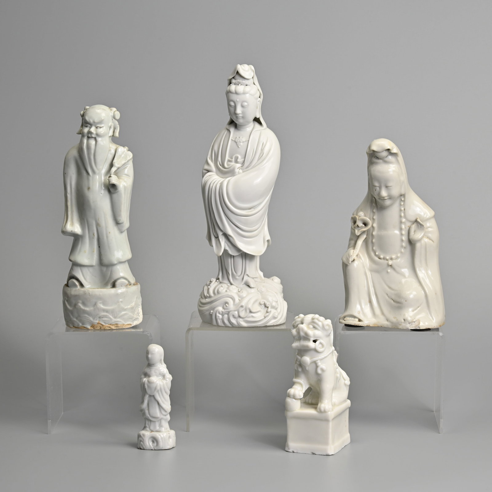 A GROUP OF CHINESE BLANC DE CHINESE PORCELAIN FIGURES, 19/20TH CENTURY.: A GROUP OF CHINESE BLANC DE CHINESE PORCELAIN FIGURES, 19/20TH CENTURY. To include a standing figure of Guanyin, four character impressed mark of He Chaozong; A seated figure of Guanyin holding a ruyi