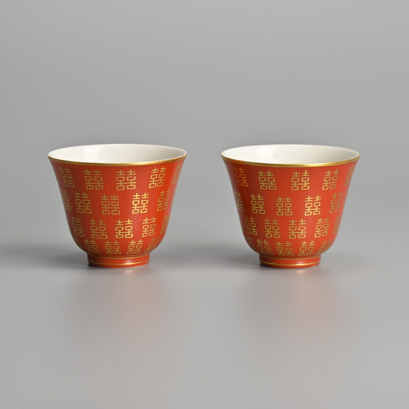 A PAIR OF CHINESE CORAL GROUND AND GILT DECORATED PORCELAIN 'SHUNAGXI' WINE CUPS, YANGXI TONGHE (1 of 6)