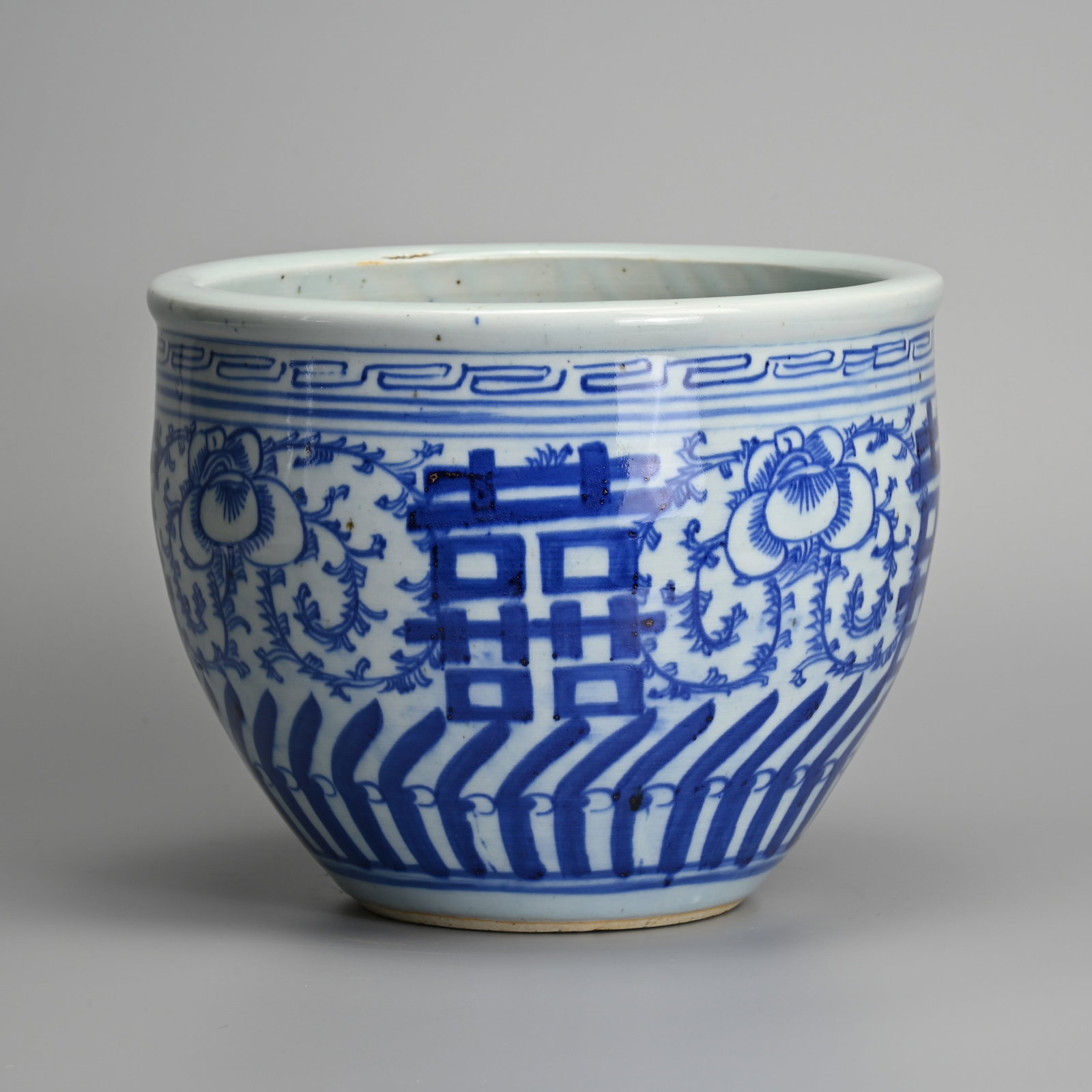 A CHINESE BLUE AND WHITE PORCELAIN 'SHUANGXI' PORCELAIN JARDINIERE, 19TH CENTURY.: A CHINESE BLUE AND WHITE PORCELAIN 'SHUANGXI' PORCELAIN JARDINIERE, 19TH CENTURY. Decorated with Double Happiness characters on sweet pea scroll ground. 25.5cm diam. x 20.5cm tall.