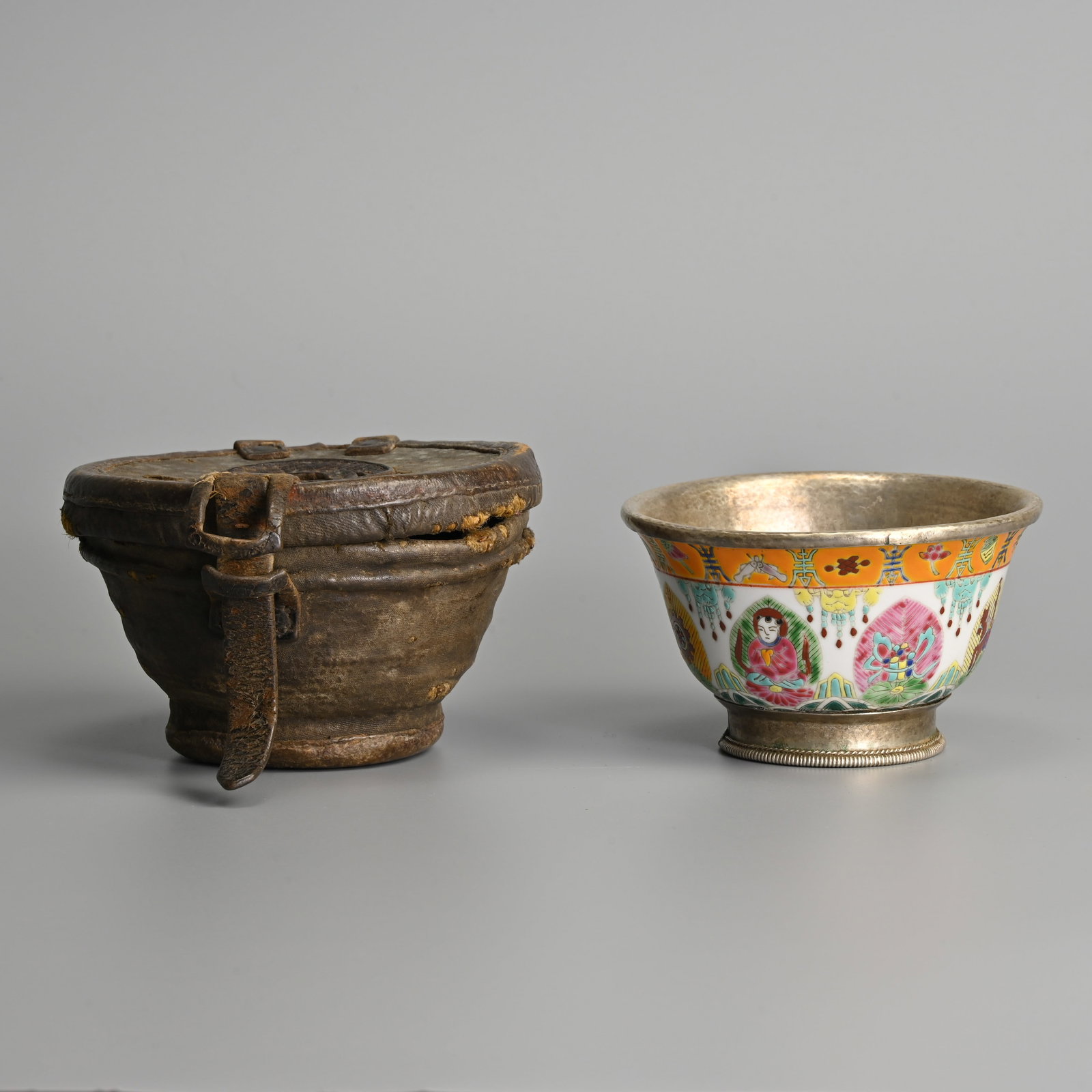 A 20TH CENTURY CHINESE FAMILLE ROSE PORCELAIN BUDDHIST BOWL IN LEATHER CASE.: A 20TH CENTURY CHINESE FAMILLE ROSE PORCELAIN BUDDHIST BOWL IN LEATHER CASE. The bowl decorated with Buddhist emblems with a white metal rim and foot, stamped China 23 Jingdezhen mark to base. Togethe