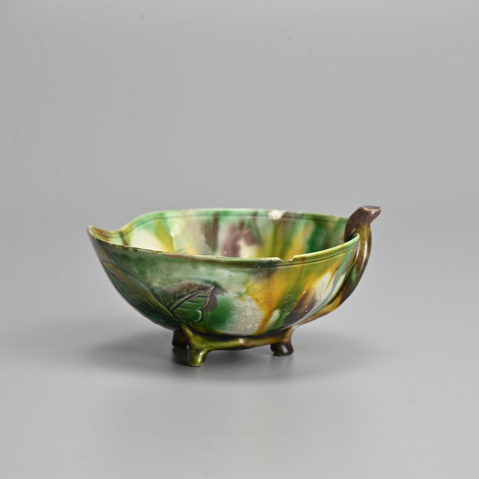 A CHINESE GREEN, EGG AND SPINACH GLAZED PORCELAIN 'PEACH' DISH, KANGXI (1662-1722).: A CHINESE GREEN, EGG AND SPINACH GLAZED PORCELAIN 'PEACH' DISH, KANGXI (1662-1722). In the form of a peach with stem handle and three feet, with moulded leaf decoration. 10.7cm length. Collection labe