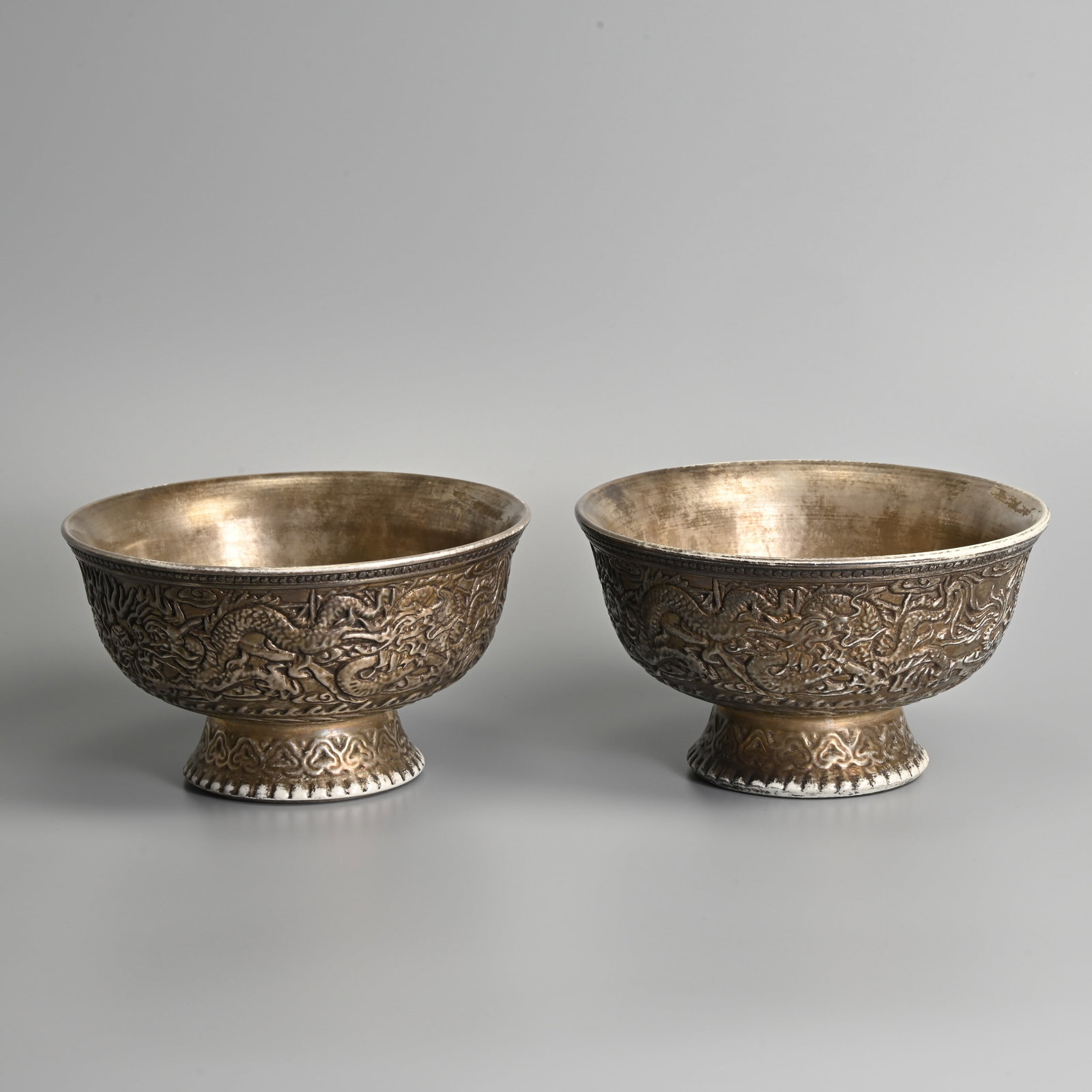 A PAIR OF CHINESE 'SILVERED' PORCELAIN 'DRAGON' FOOTED BOWLS, QIANLONG MARKS.: A PAIR OF CHINESE 'SILVERED' PORCELAIN 'DRAGON' FOOTED BOWLS, QIANLONG MARKS. Fairly heavily potted with deep rounded sides with gently everted rims on a splayed foot, decorated in relief to the exter