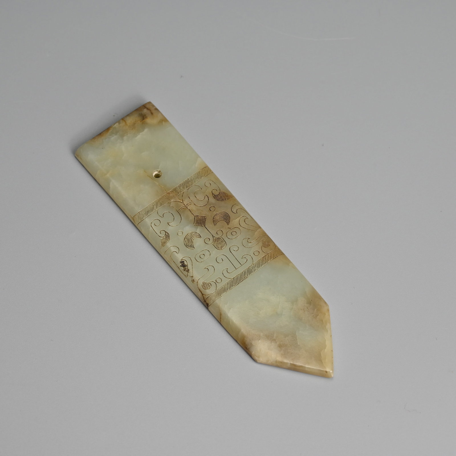 A CHINESE ARCHAISTIC PALE CELADON JADE 'TAOTIE MASK' BLADE, GUI, MING DYNASTY. (1 of 5)