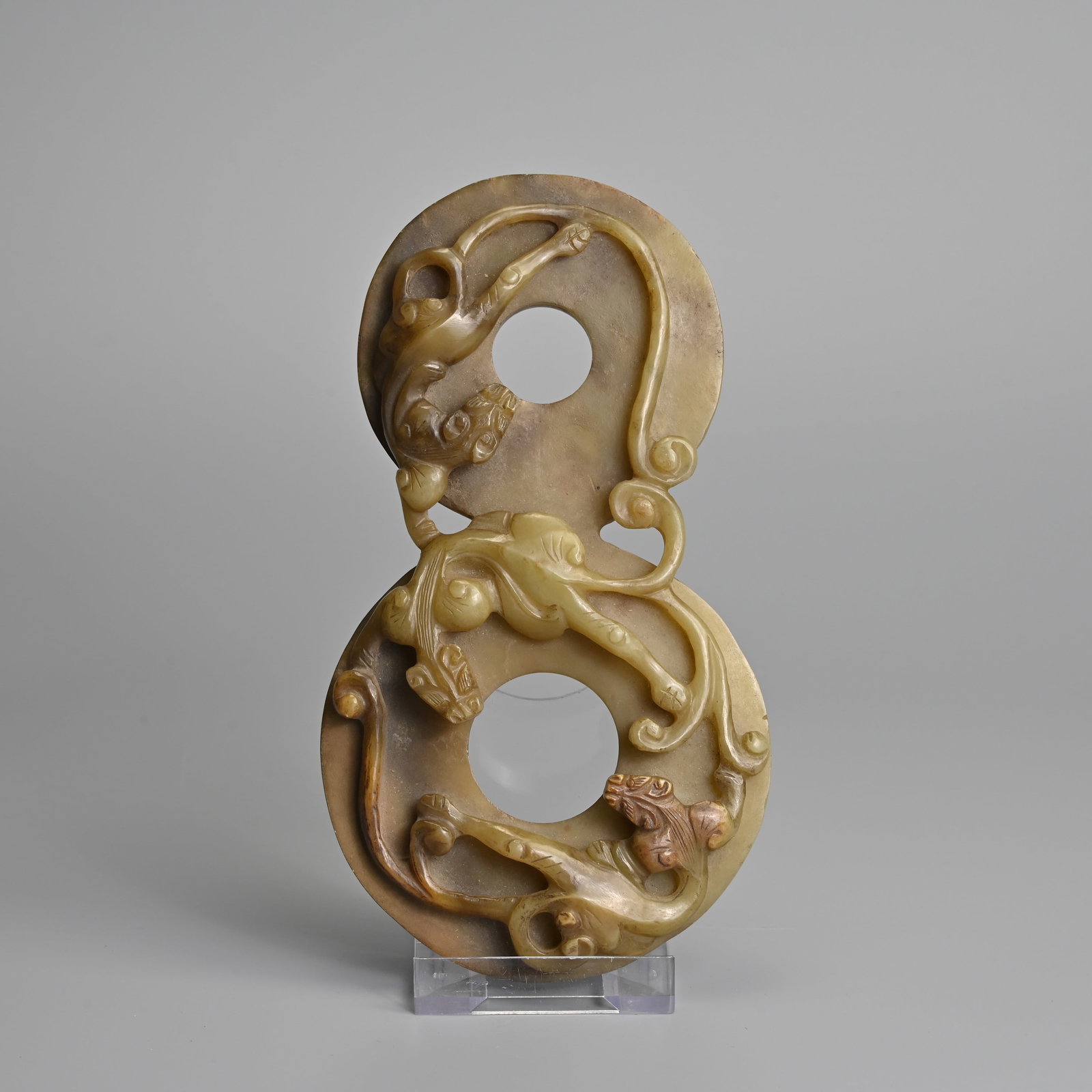 A CHINESE ARCHAISTIC CONJOINED BI DISC JADE PENDANT WITH CHILONGS.: A CHINESE ARCHAISTIC CONJOINED BI DISC JADE PENDANT WITH CHILONGS. Featuring three chilongs in deep relief on graduated bi discs. 17.5cm length, larger disc 9.5cm diam.