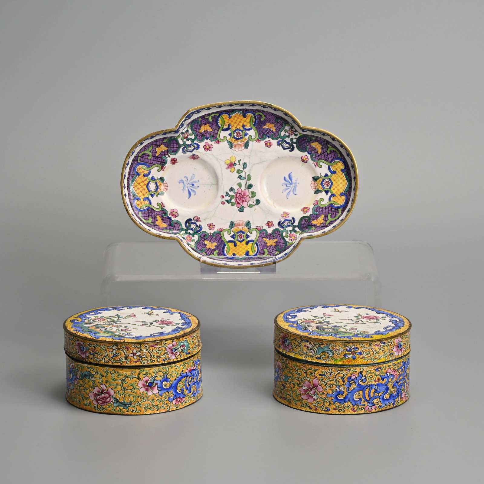 A PAIR OF CHINESE CANTON ENAMEL BOXES AND COVERS TOGETHER WITH A SAUCER TRAY, 18/19TH CENTURY.: A PAIR OF CHINESE CANTON ENAMEL BOXES AND COVERS TOGETHER WITH A SAUCER TRAY, 18/19TH CENTURY. The pair of circular boxes and covers decorated with blue enamelled dragons amidst floral scrolls on a ye