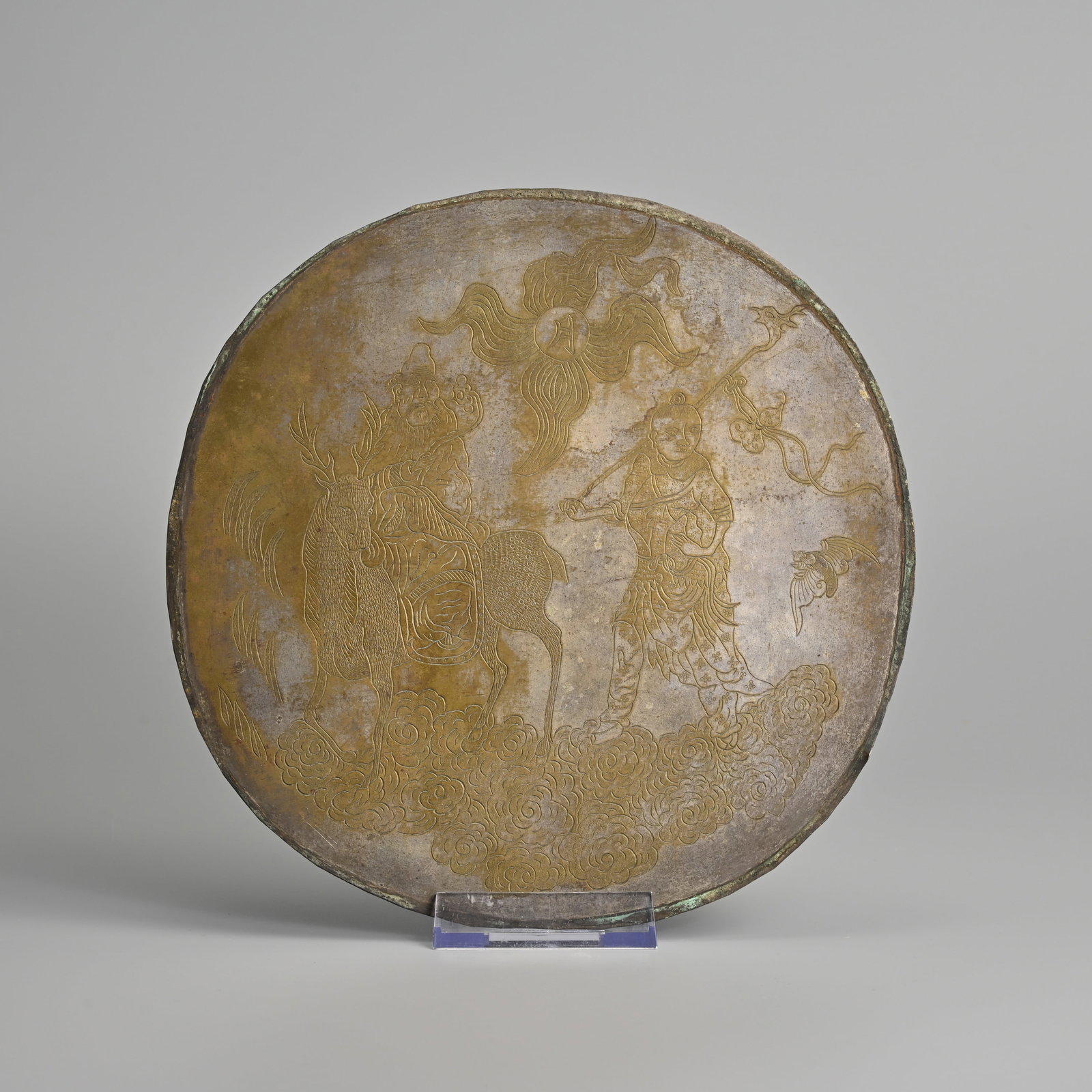 A CHINESE ENGRAVED WHITE METAL CIRCULAR 'SHOULAO' PANEL, QING DYNASTY.: A CHINESE ENGRAVED WHITE METAL CIRCULAR 'SHOULAO' PANEL, QING DYNASTY. Featuring the god of longevity seated on a deer with follower holding a peach on a cloud, with moon and bat. 20cm diam.
