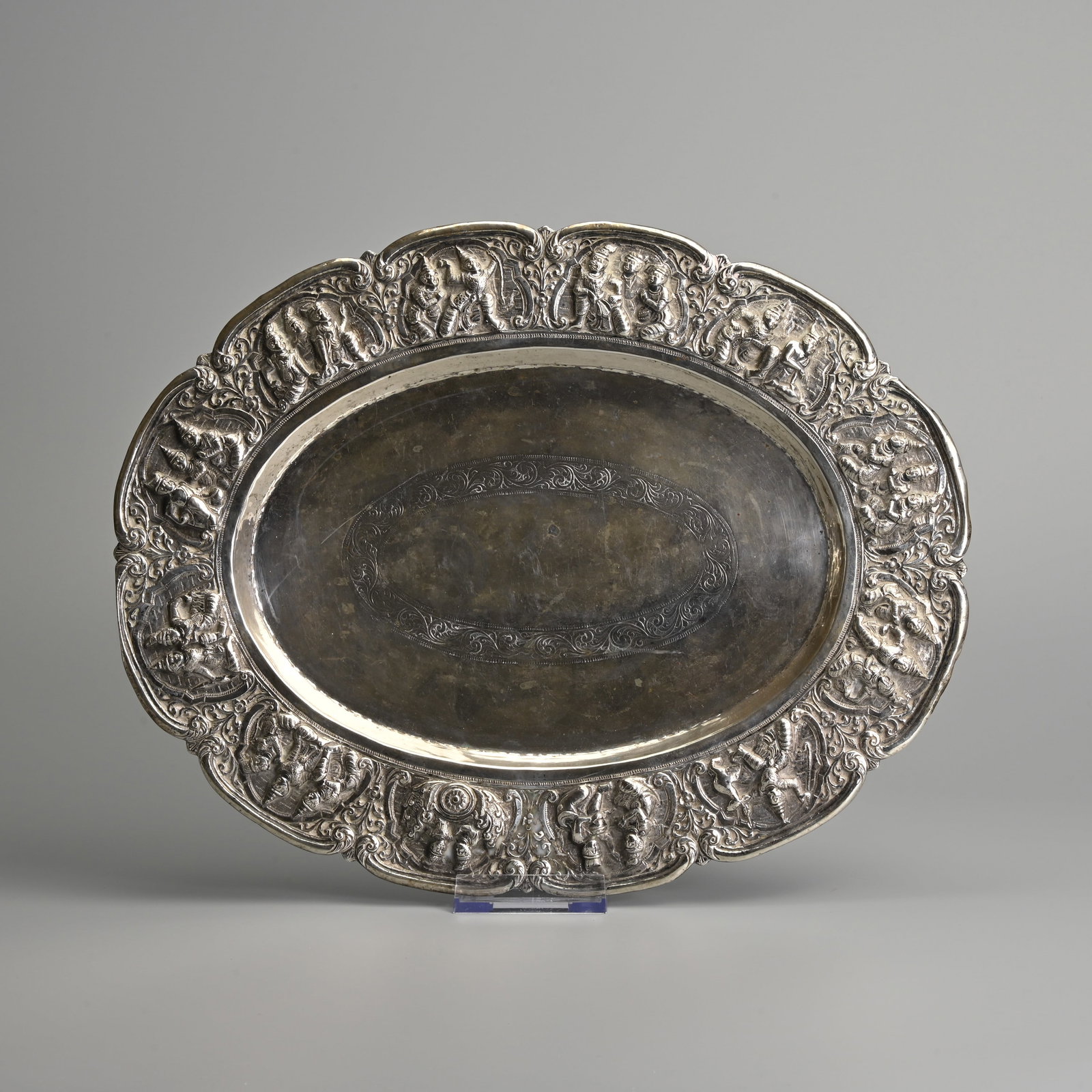 A BURMESE REPOUSSE DECORATED SILVER LOBED TRAY, EARLY TO MID 20TH CENTURY.: A BURMESE REPOUSSE DECORATED SILVER LOBED TRAY, EARLY TO MID 20TH CENTURY. Decorated in relief to the edge with various attendants. Marked to base 95/Silver, Burma. 33.5cm wide. Weight 365 grams.