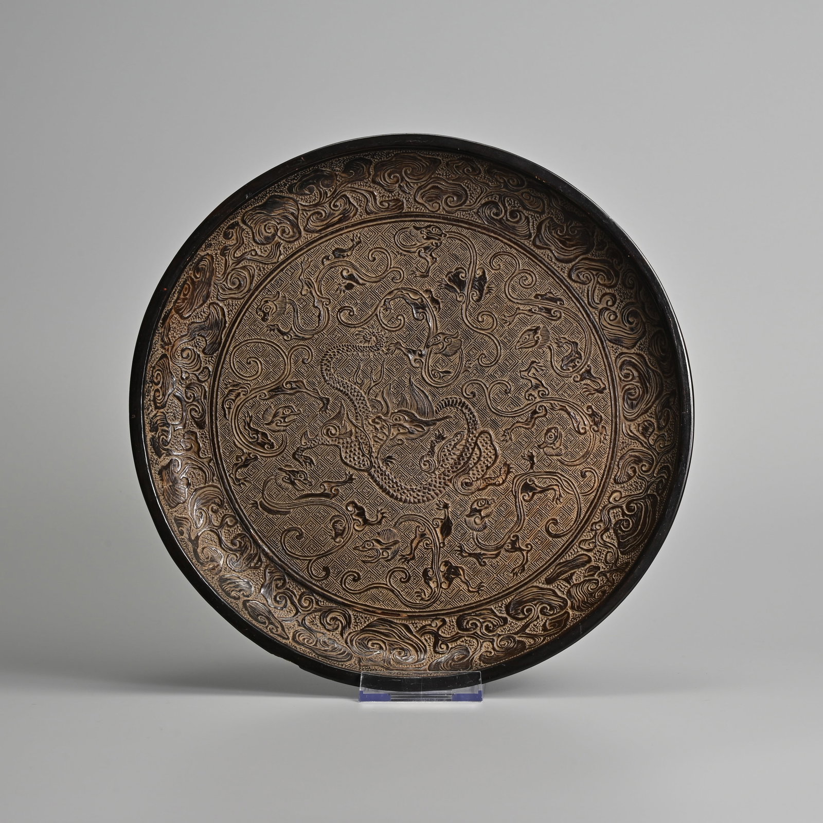 A CHINESE BROWN LACQUER 'NINE DRAGON' DISH, 19/20TH CENTURY.: A CHINESE BROWN LACQUER 'NINE DRAGON' DISH, 19/20TH CENTURY. Featuring a central dragon surrounded by eight smaller chilong dragons within a band of lingzhi fungus 27.5cm diam.