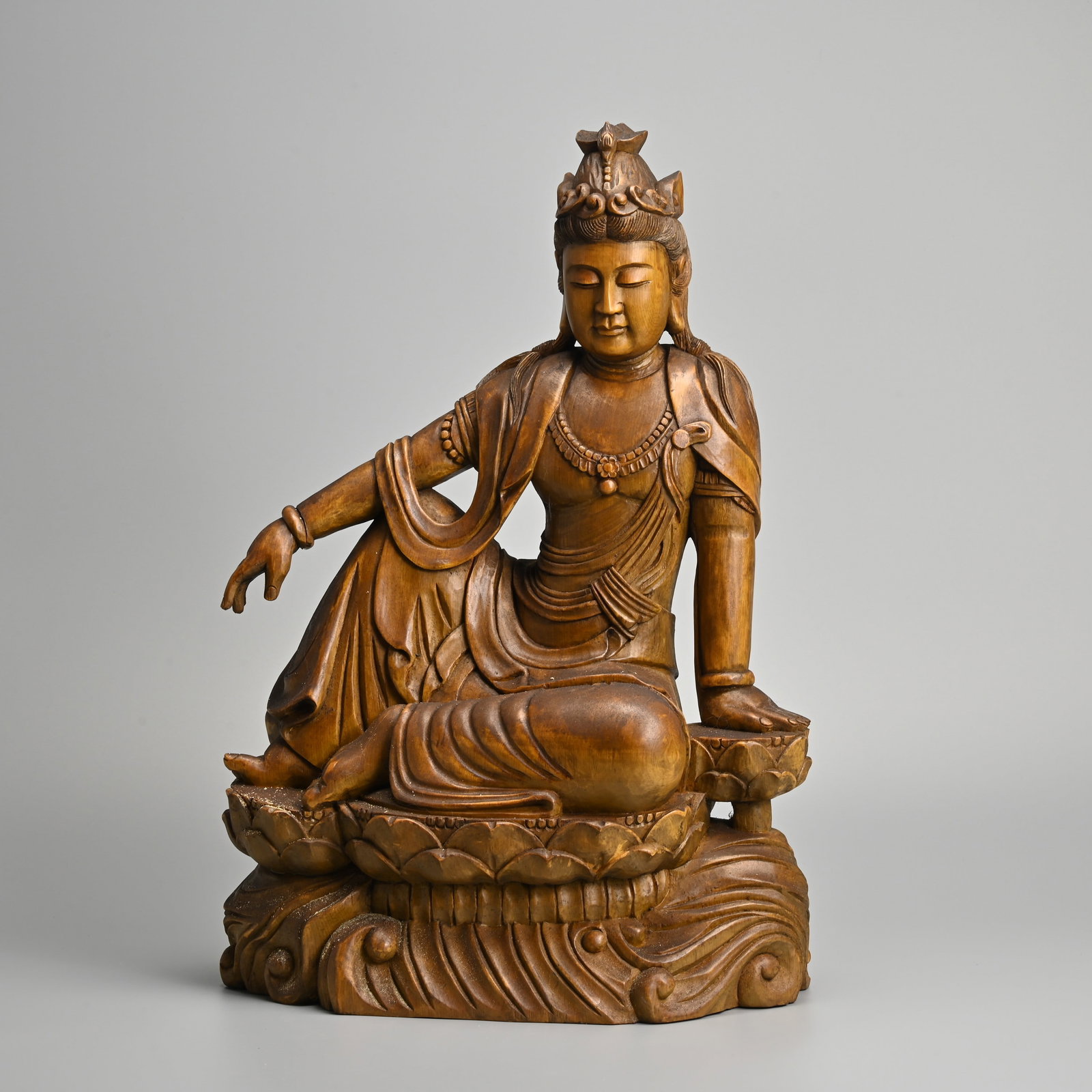 A LARGE CHINESE CARVED WOOD FIGURE OF GUANYIN, LATE 20TH CENTURY.: A LARGE CHINESE CARVED WOOD FIGURE OF GUANYIN, LATE 20TH CENTURY. Seated on a lotus base. 46cm tall x 31.5cm wide x 18.5cm deep, weight 5.1kg.