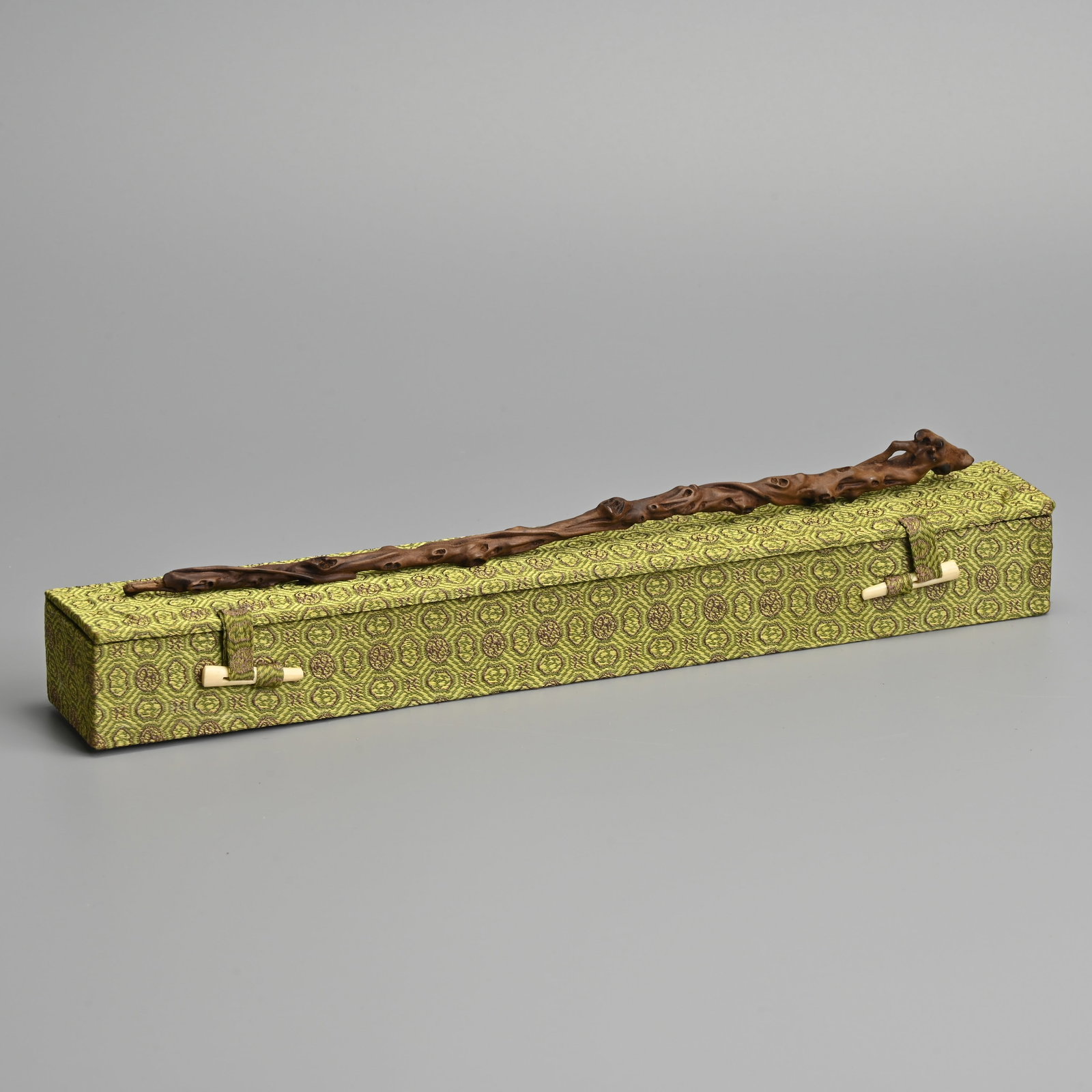 A CHINESE CARVED HUANGYANGMU, BOXWOOD, SCHOLAR'S TABLE SCEPTRE, POSSIBLY QING DYNASTY.: A CHINESE CARVED HUANGYANGMU, BOXWOOD, SCHOLAR'S TABLE SCEPTRE, POSSIBLY QING DYNASTY. Naturalistic carved as a gnarled branch with vines. Together with a silk box. Sceptre 27cm length.