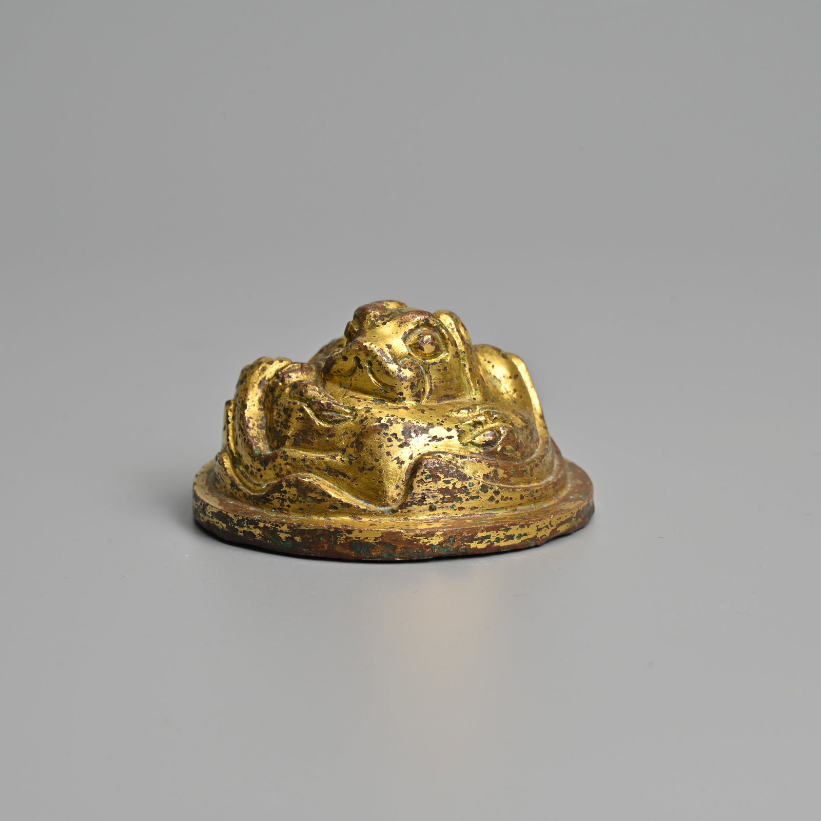 A CHINESE CIRCULAR GILT BRONZE 'LION' WEIGHT. (1 of 6)
