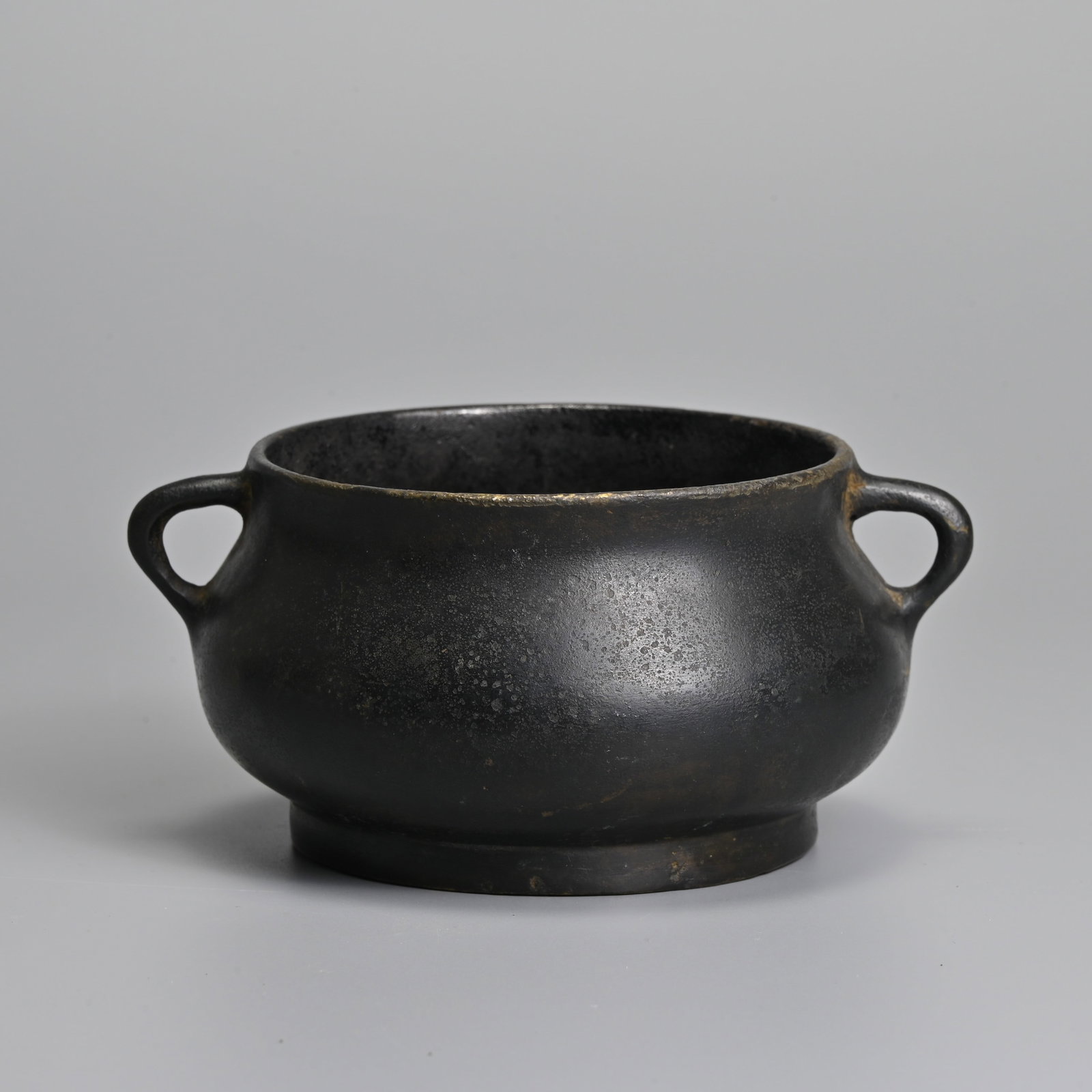A CHINESE BRONZE BOMBE FORM CENSER, XUANDE MARK, QING DYNASTY.: A CHINESE BRONZE BOMBE FORM CENSER, XUANDE MARK, QING DYNASTY. With six character mark of Xuande in relief to base. 13.5cm wide including handles.