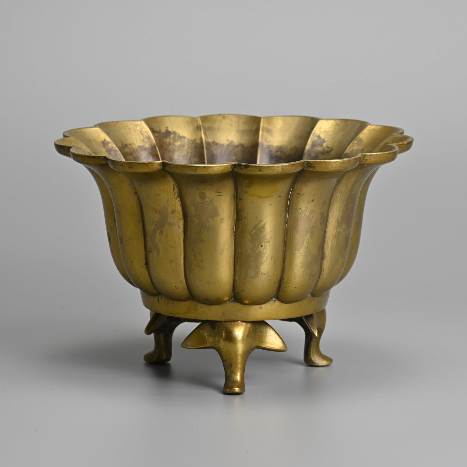 A CHINESE BRONZE 'FLOWER SHAPED' TRIPOD CENSER, 19/20TH CENTURY.: A CHINESE BRONZE 'FLOWER SHAPED' TRIPOD CENSER, 19/20TH CENTURY. Raised of four feet with lobed bowl. Four character mark to base. 16.5cm diam.
