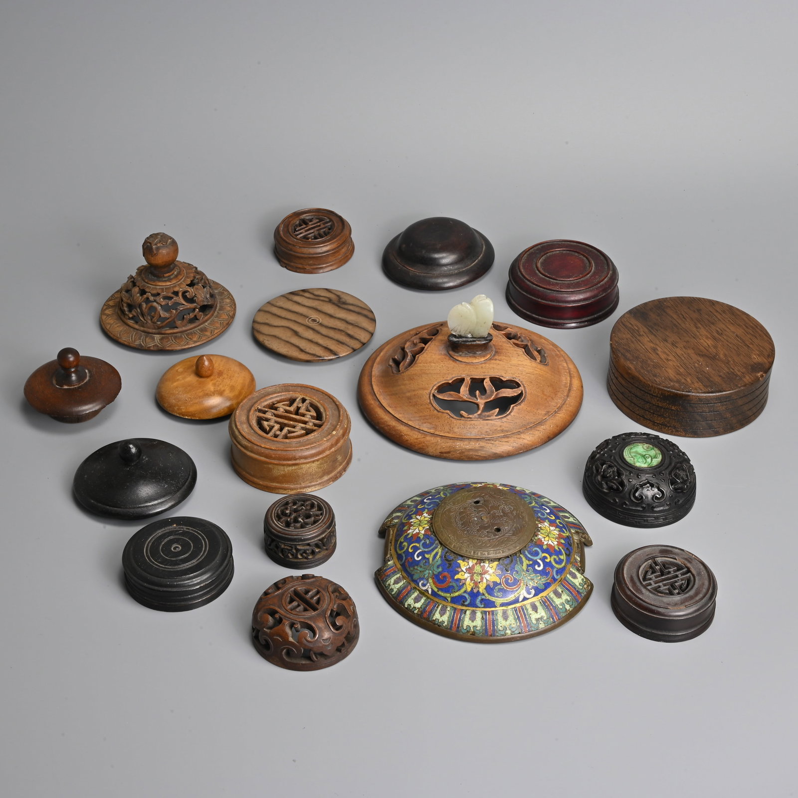 A QUANTITY OF CHINESE HARDWOOD AND ENAMELLED COVERS, 19/20TH CENTURY.: A QUANTITY OF CHINESE HARDWOOD AND ENAMELLED COVERS, 19/20TH CENTURY. Of various forms to include a carved and pierced cover with a pale celadon jade finial; A finely carved and pierced cover with ruy