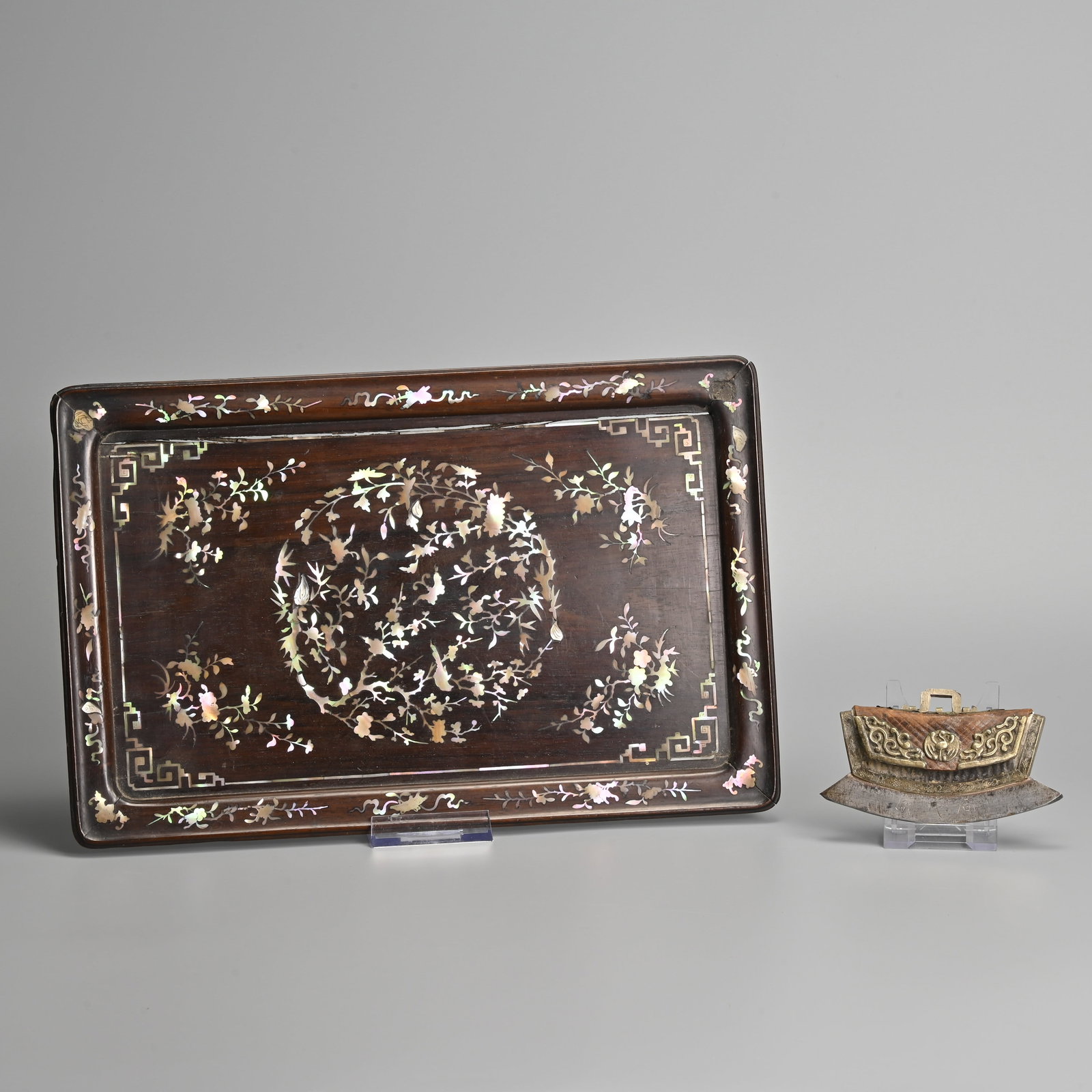 A TIBETAN LEATHER CASED TINDER POUCH, CHUCKMUCK, TOGETHER WITH A CHINESE MOTHER OF PEARL INLAID WOOD: A TIBETAN LEATHER CASED TINDER POUCH, CHUCKMUCK, TOGETHER WITH A CHINESE MOTHER OF PEARL INLAID WOOD TRAY, 19/20TH CENTURY. The pouch fitted with brass fittings decorated with a phoenix roundel flanke