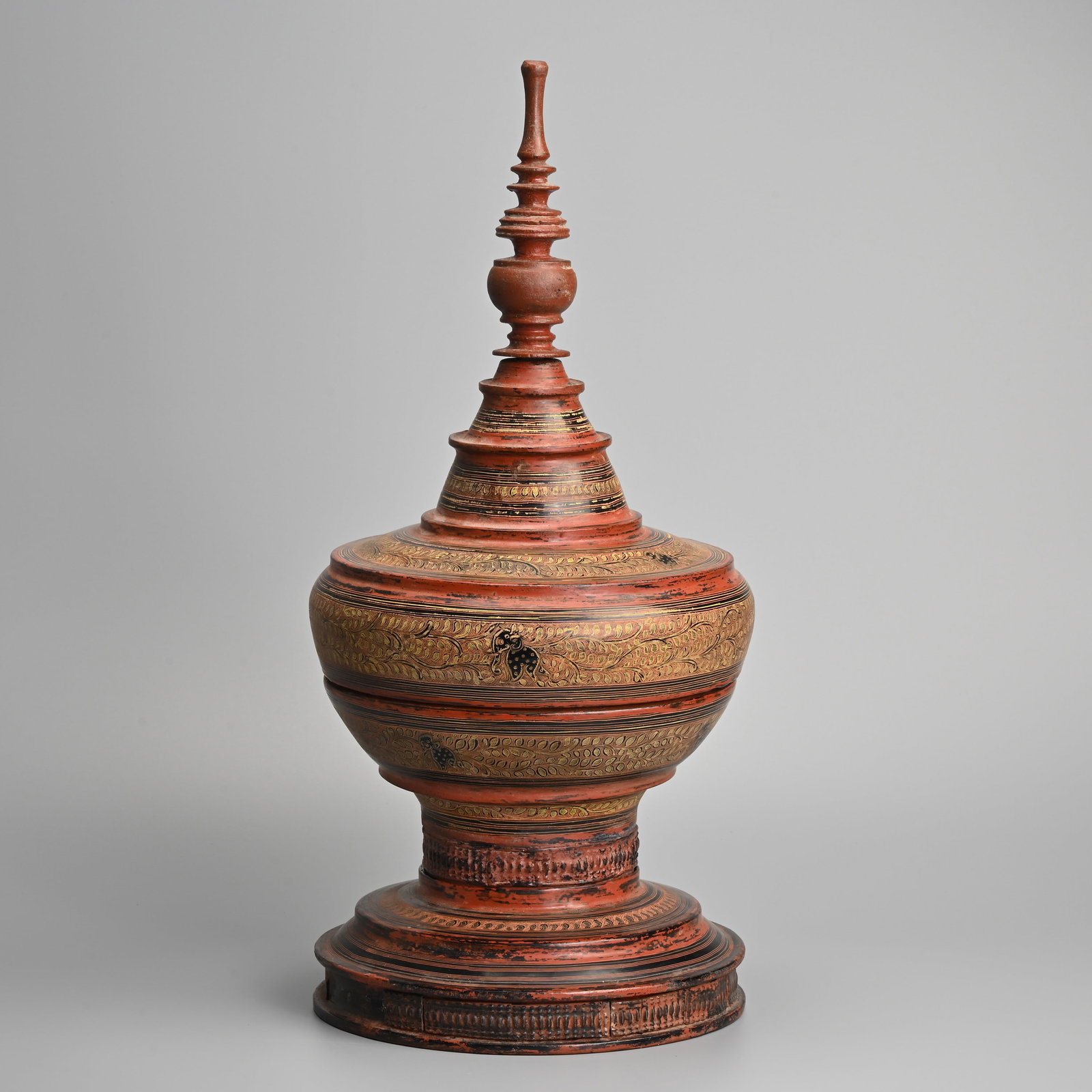 A BURMESE LACQUER OFFERING BOX AND COVER, HSUN-OK, 19/20TH CENTURY.: A BURMESE LACQUER OFFERING BOX AND COVER, HSUN-OK, 19/20TH CENTURY. Sectional wood with bamboo box and cover on stand topped with finial, decorated with elephants and leafy scrolls. The interior with 