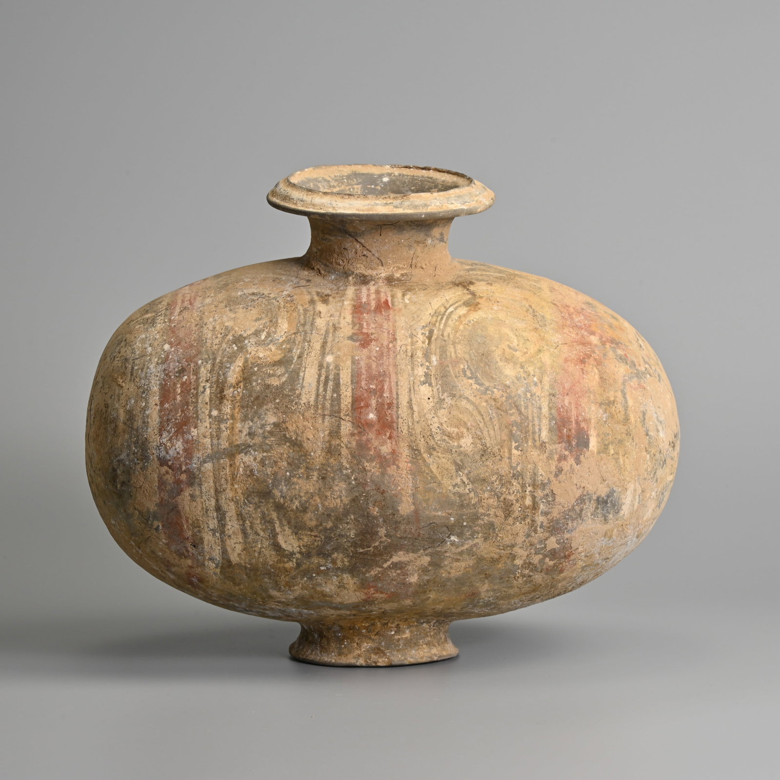 A CHINESE PAINTED GREY POTTERY COCOON JAR, WESTERN HAN DYNASTY (206 BC - AD 8).: A CHINESE PAINTED GREY POTTERY COCOON JAR, WESTERN HAN DYNASTY (206 BC - AD 8). Decorated with various cold painted coloured pigments featuring swirling cloud patterns within vertical and geometric ba