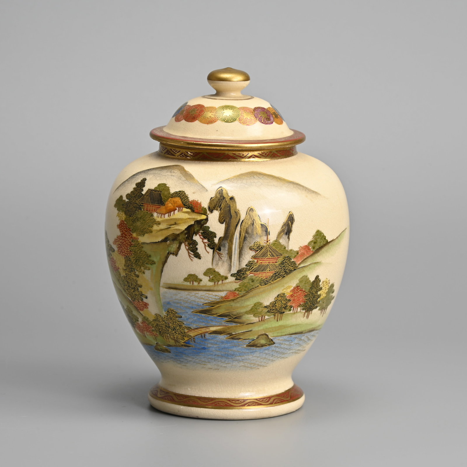A JAPANESE SATSUMA WARE JAR AND COVER, KOSHIDA, 20TH CENTURY.: A JAPANESE SATSUMA WARE JAR AND COVER, KOSHIDA, 20TH CENTURY. Decorated with buildings in landscape scene. Gilt mark Koshida to base. 18cm tall.