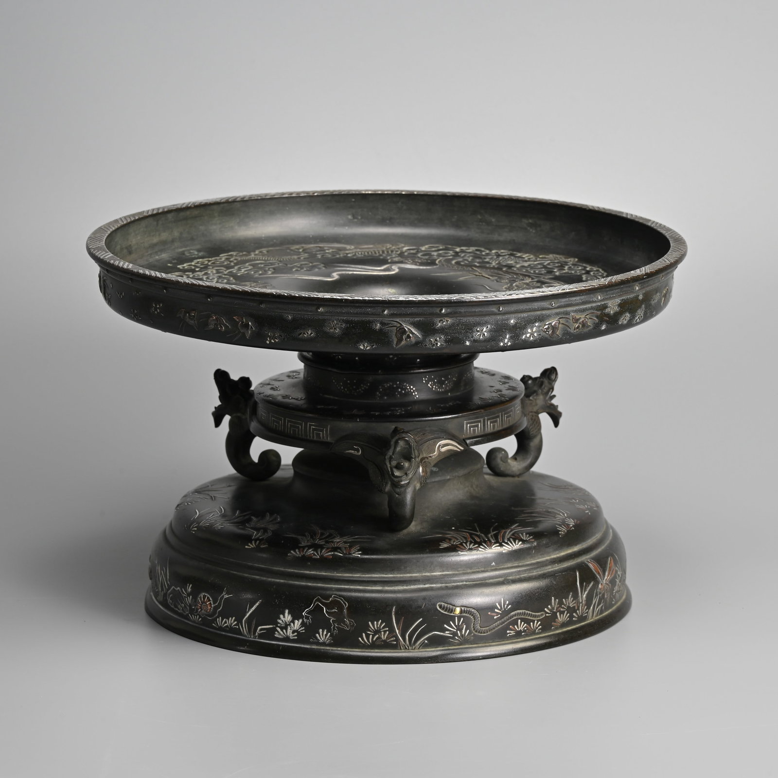 A JAPANESE BRONZE USUBATA VASE WITH TAKA ZOGAN DECORATION, TAISHO / SHOWA PERIOD.: A JAPANESE BRONZE USUBATA VASE WITH TAKA ZOGAN DECORATION, TAISHO / SHOWA PERIOD. White metal and copper relief decorated with a large circular dish section decorated with minogame and dragon amidst c