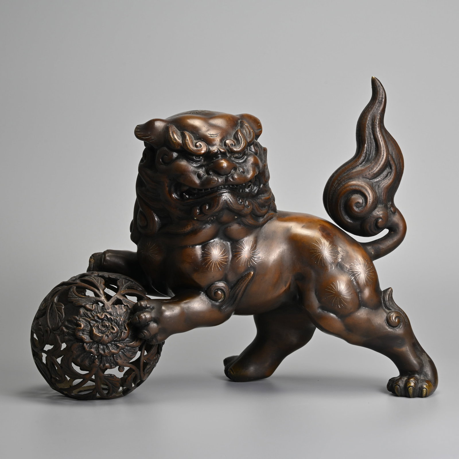 A JAPANESE BRONZE SHISHI AND BALL, 20TH CENTURY.: A JAPANESE BRONZE SHISHI AND BALL, 20TH CENTURY. The powerful guardian lion standing with its front paws on a separately cast open work pierced brocade ball. 26.5cm high x 36.5cm long x 15cm deep, wei