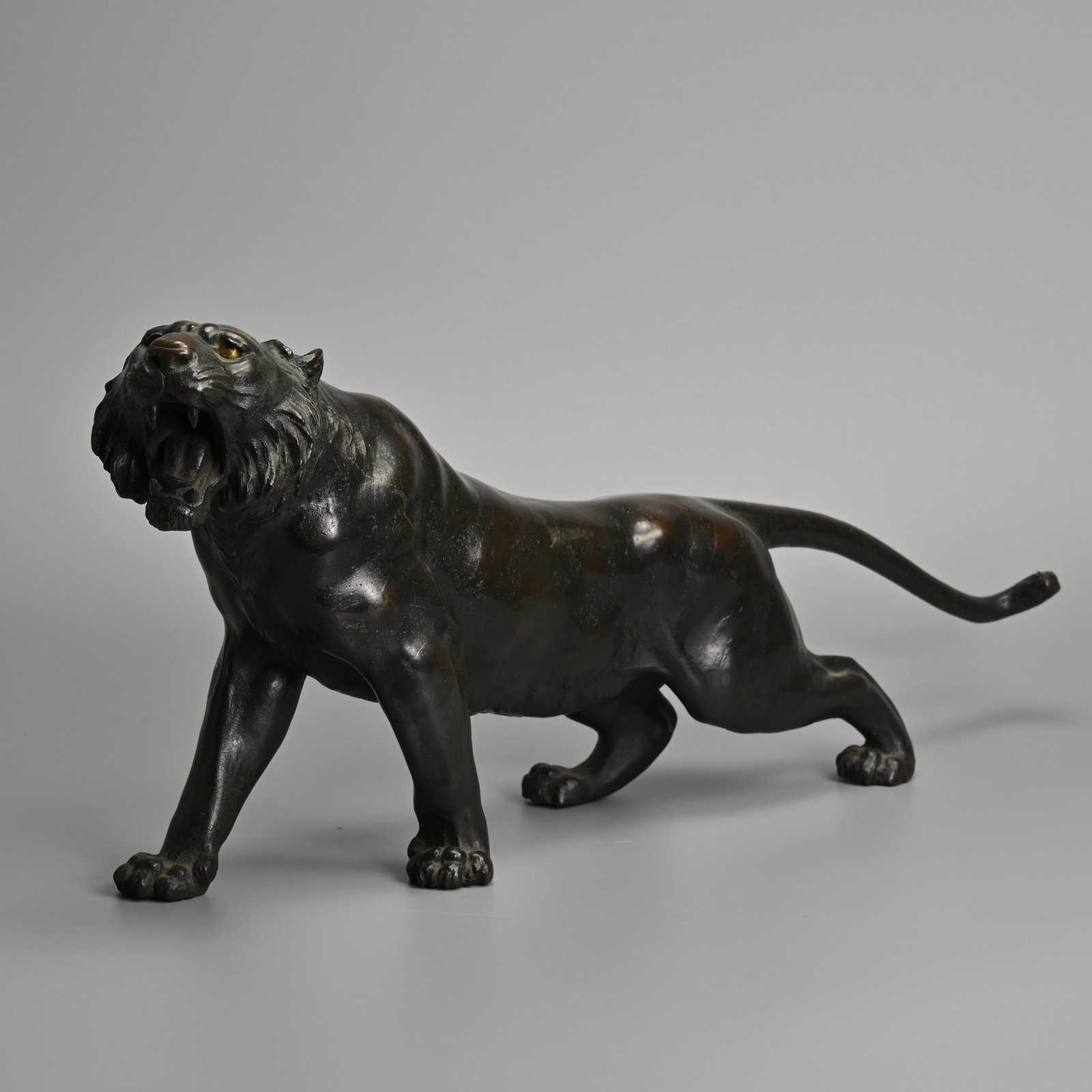 A LARGE JAPANESE BRONZE OKIMONO OF A TIGER, SHORYUSAI CHIKATOSHI, ACTIVE CIRCA 1900.: A LARGE JAPANESE BRONZE OKIMONO OF A TIGER, SHORYUSAI CHIKATOSHI, ACTIVE CIRCA 1900. Well cast figure of a roaring tiger, signed to the underside of the rear left leg. 22cm high x 48cm long x 9cm deep