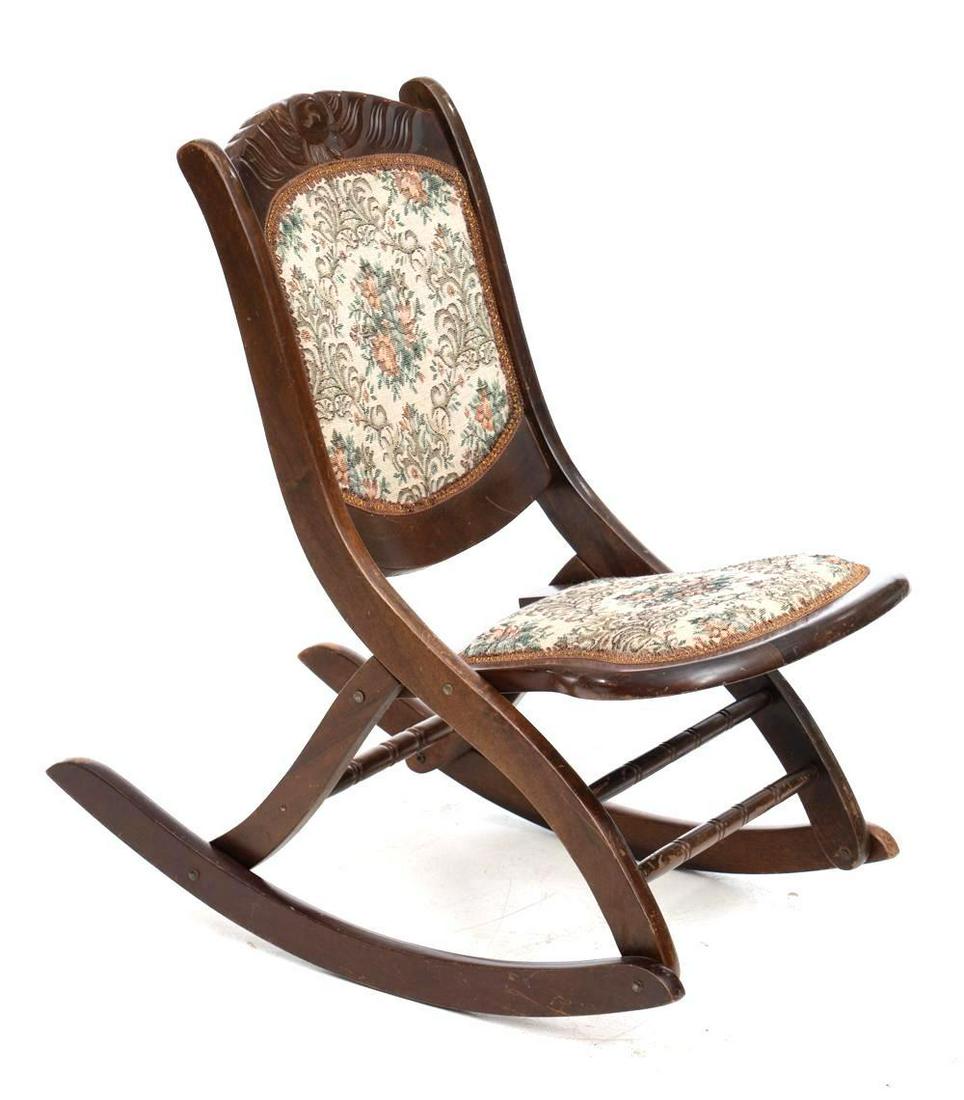 Needle Point Folding Rocking Chair: Floral accents, carved mantle, gilt trim around fabric. Condition: Scuffs 31" tall x 17.5" wide x 30" deep