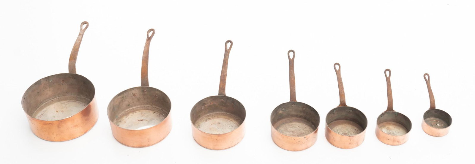 Lot of 7 Copper Pots: Graduated pot set, copper pots with iron handles. Condition: Light abrasions, oxidization 16" long/ Largest