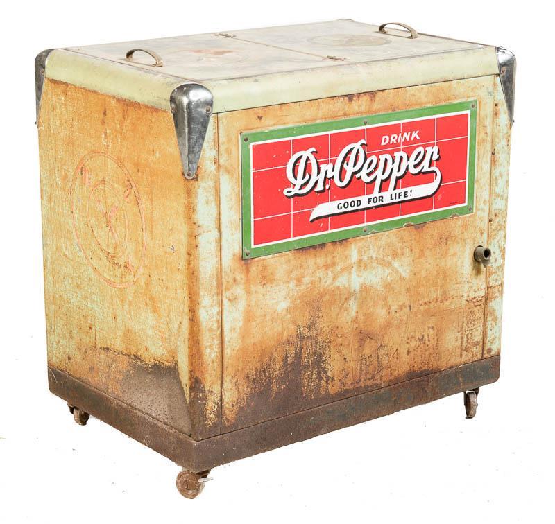 Dr. Pepper Cooler: Provenance: A Boerne, TX Estate Rustic Dr. Pepper cooler, metal frame, hand-painted lettering, 2-hinged top lids, metal handles, on casters 36" tall x 36" wide x 24.5" deep Condition: Oxidized State-w