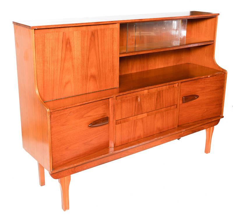 Mid-Century Teak Cabinet: Mid-Century teak sideboard, single-drop front door, wooden drawer pulls, liquor cabinet-motif 48" tall x 65.5" wide x 17" deep State-wide delivery is available for this item. Please email shipping@vog