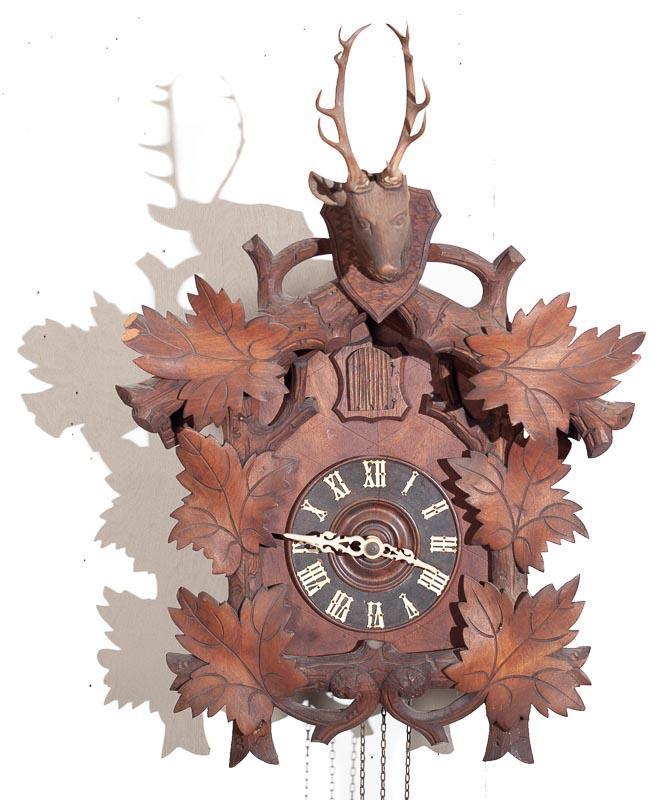 Cuckoo Wall Clock with Brass Plate Movement: Provenance: The Estate of Andy and Bea Copeland Cuckoo wall clock with brass plate movement 22” tall x 16” wide Condition: broken leaf carving, damage to crest Note: This antique clock is 