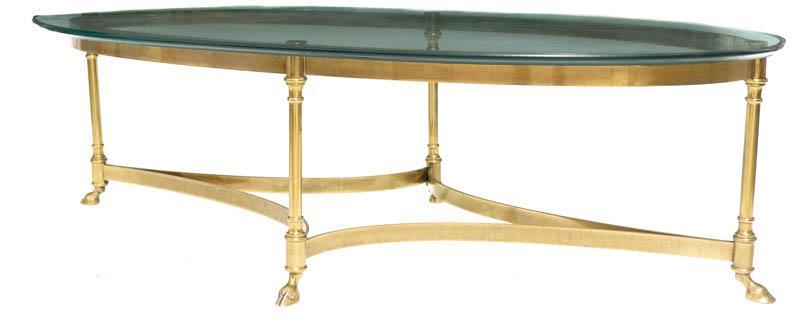 French Hoof Foot Coffee Table: Provenance: An Adkins, TX Estate French hoof foot coffee table, thick tinted glass, brass base 15" tall x 51" wide x 26" deep Condition: Mild damage to glass State-wide delivery is available for this 